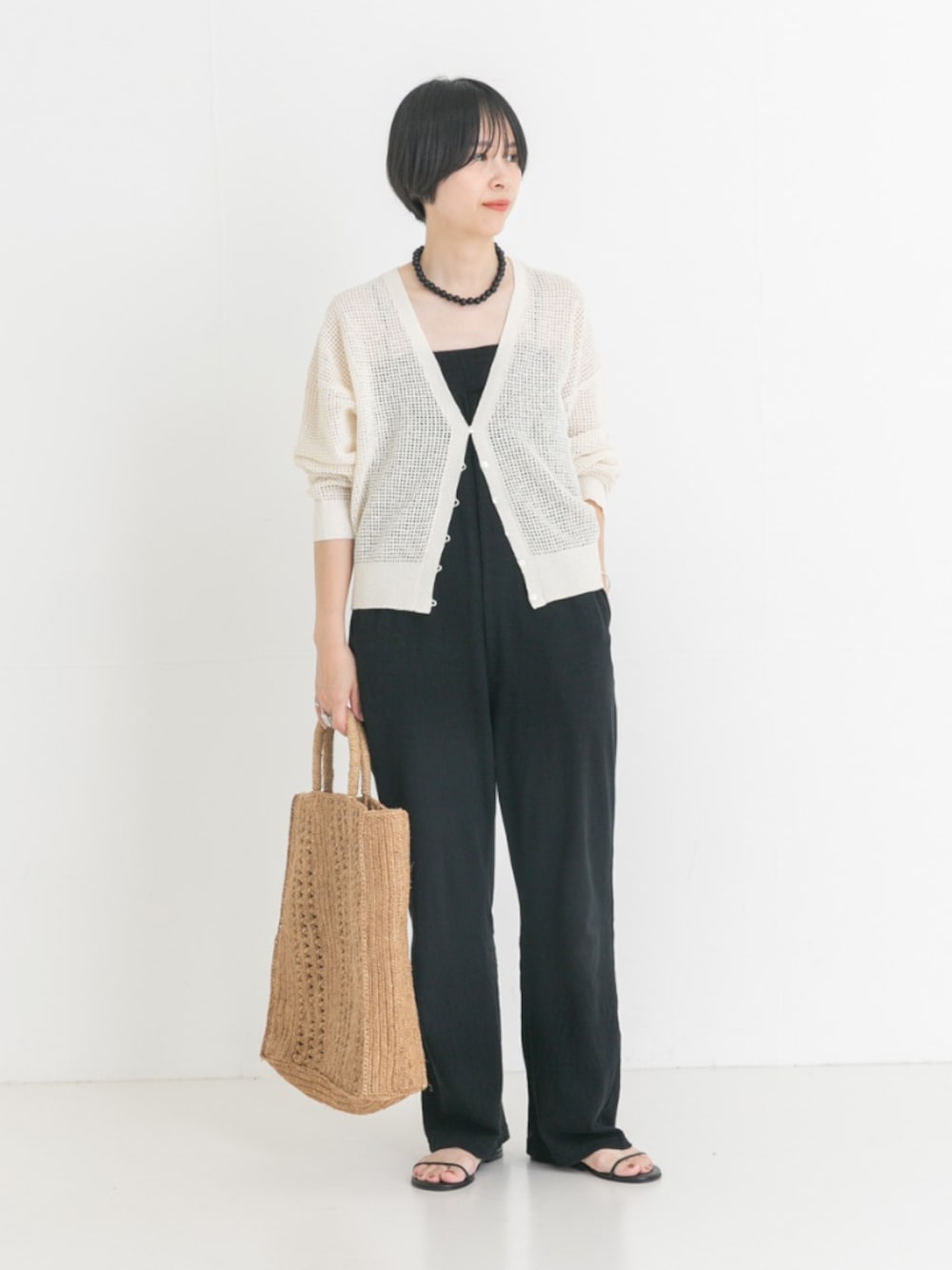 ホワイト系のカーディガン/ボレロ、ブラック系のサンダル、ブラック系のサロペット/オーバーオールを着用したレディースの夏コーディネートの1枚目の写真