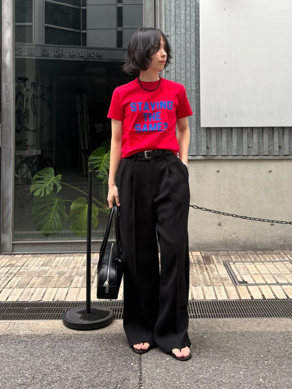 ブラック系のその他パンツ、ブラック系のショルダーバッグ、レッド系のTシャツ/カットソーを着用したレディースの冬コーディネートの1枚目の写真