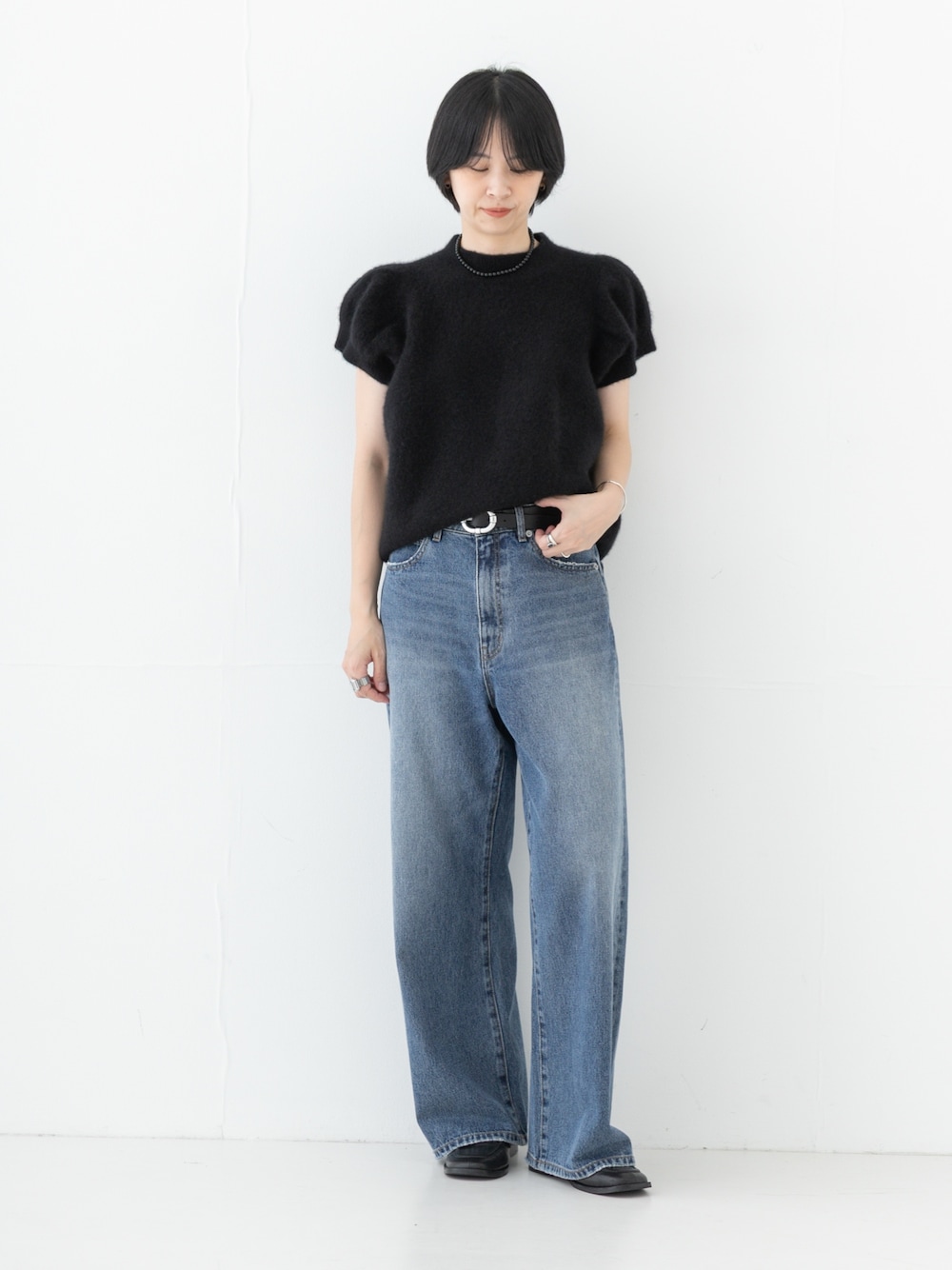 ブルー系のデニムパンツ、ブラック系のベルトを着用したレディースの秋コーディネートの1枚目の写真