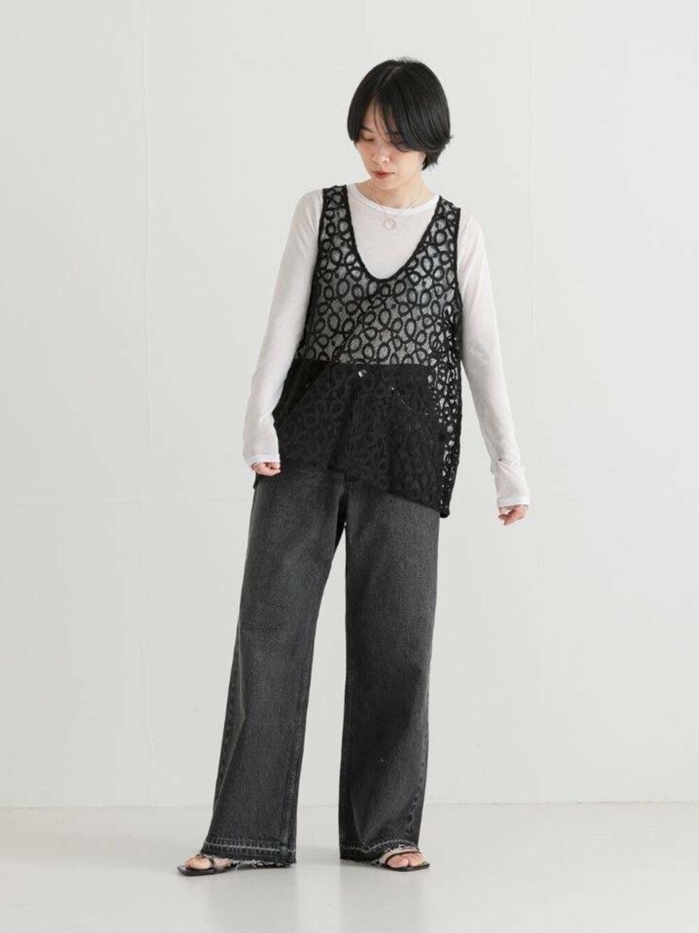 ブラック系のサンダル、ホワイト系のTシャツ/カットソー、ブラック系のベストを着用したレディースの夏コーディネートの1枚目の写真