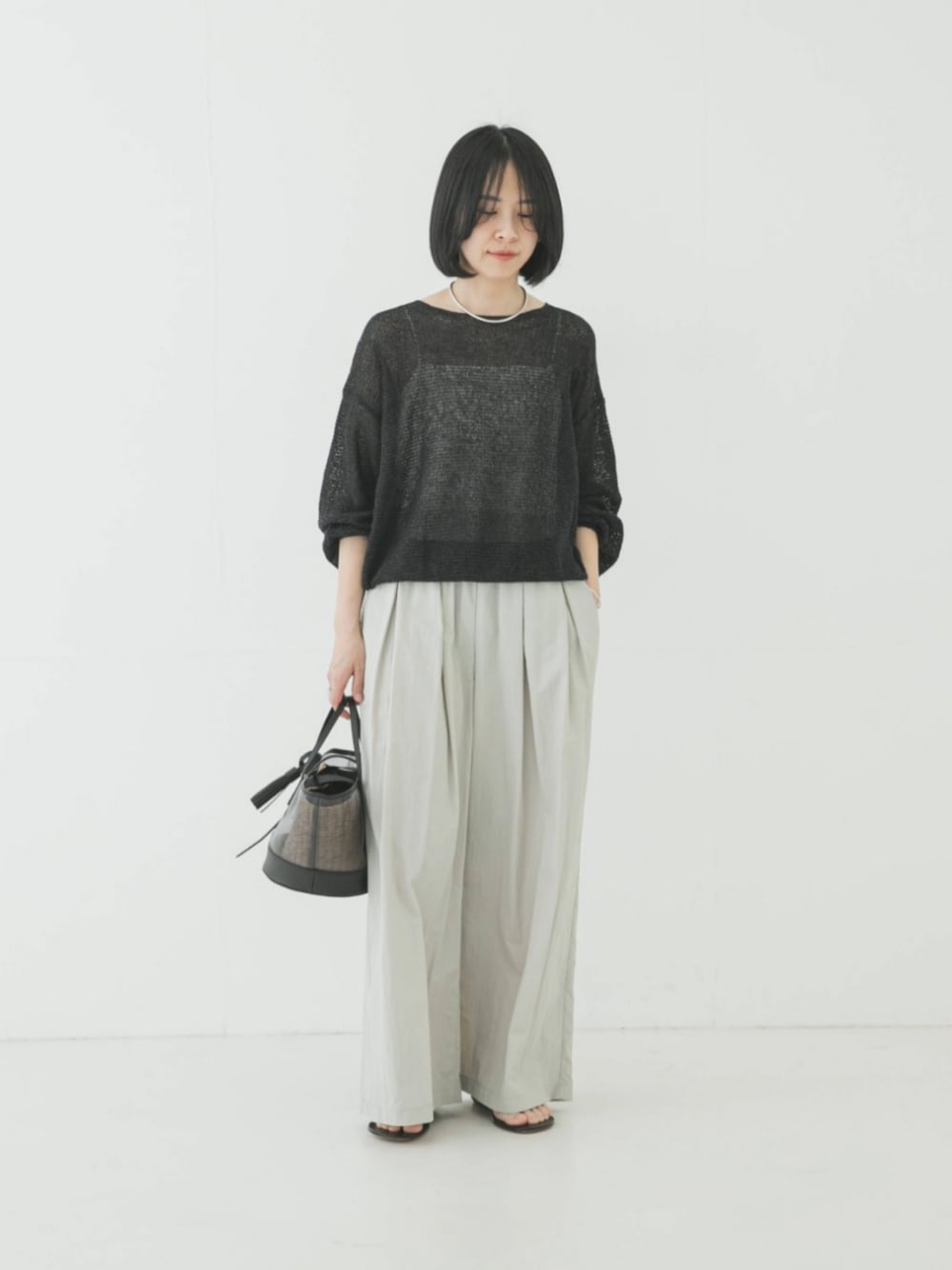 グレー系のニット/セーター、グレー系のその他パンツを着用したレディースの春コーディネートの1枚目の写真