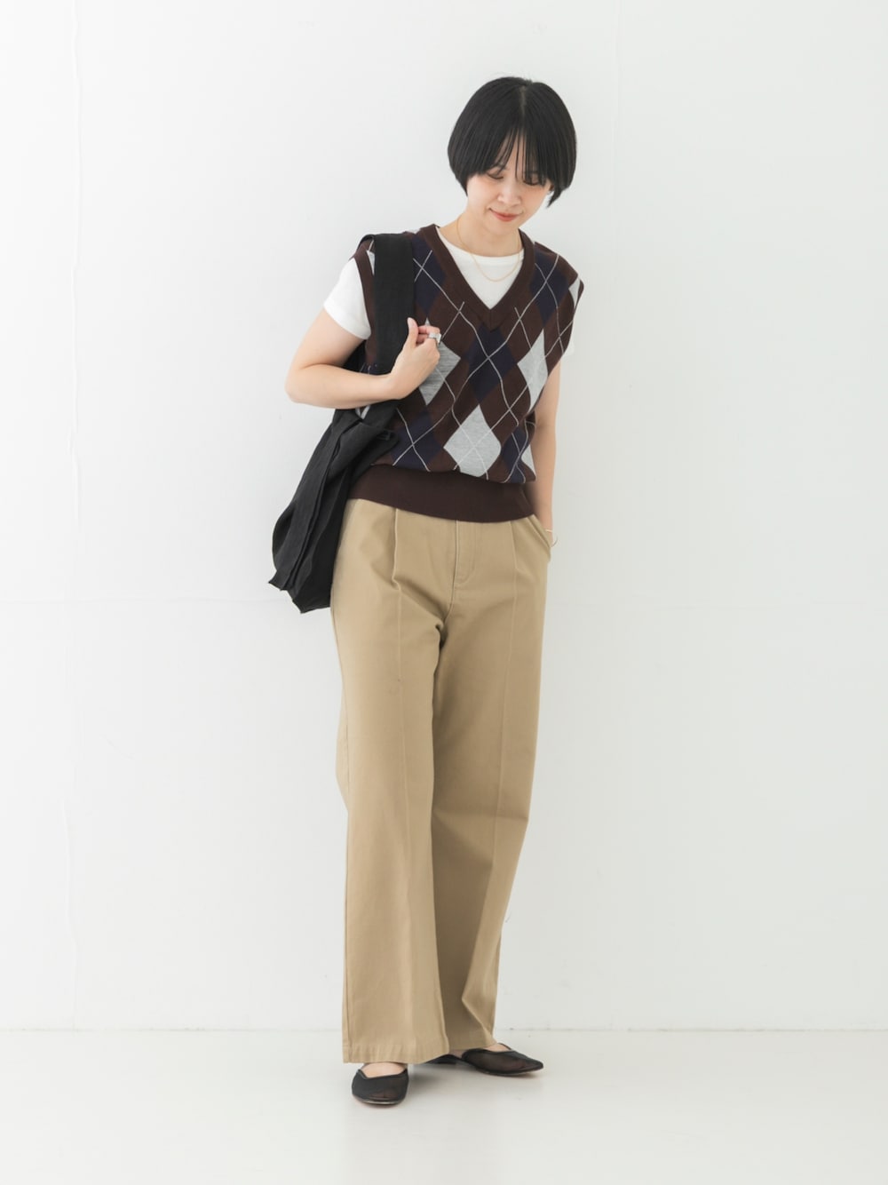 ベージュ系のその他パンツ、ブラック系のトートバッグ、ブラウン系のベストを着用したレディースの夏コーディネートの1枚目の写真