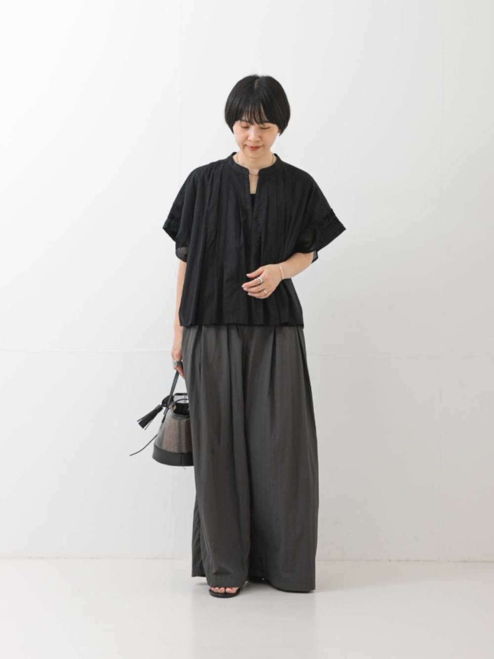 ブラック系のシャツ/ブラウス、ブラック系のかごバッグ、グレー系のその他パンツを着用したレディースの夏コーディネートの1枚目の写真