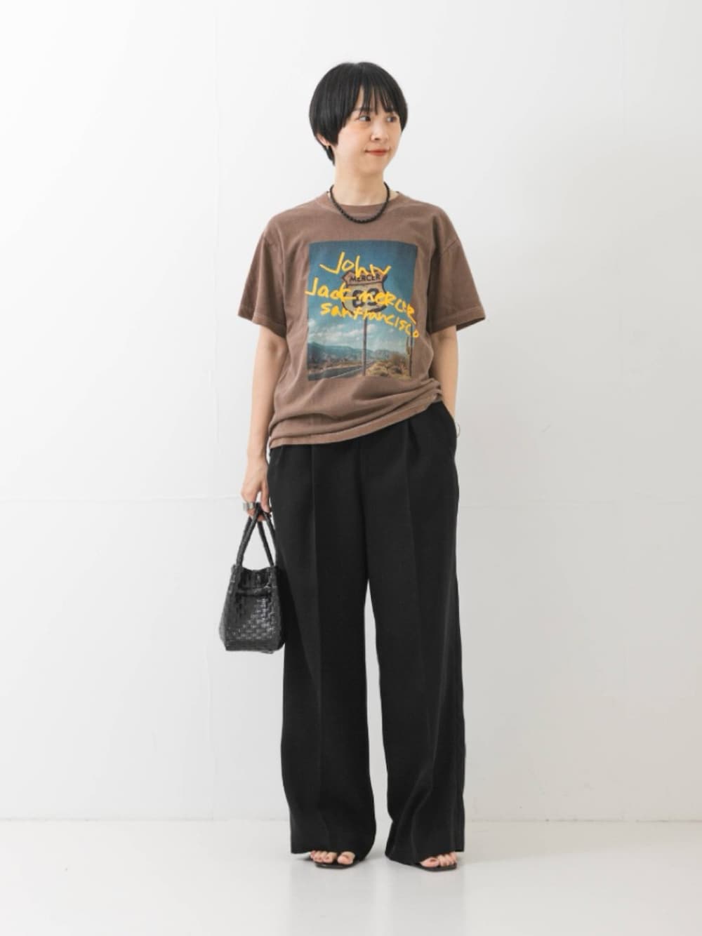 ブラウン系のTシャツ/カットソー、ブラック系のその他パンツ、ブラック系のトートバッグを着用したレディースの夏コーディネートの1枚目の写真