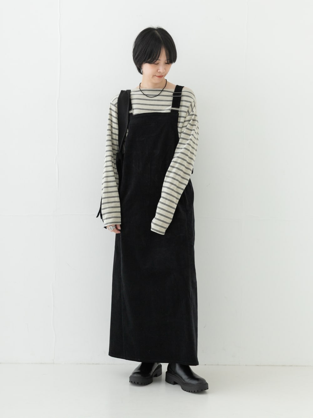ホワイト系のTシャツ/カットソー、ブラック系のブーツ、ブラック系のワンピースを着用したレディースの秋コーディネートの1枚目の写真