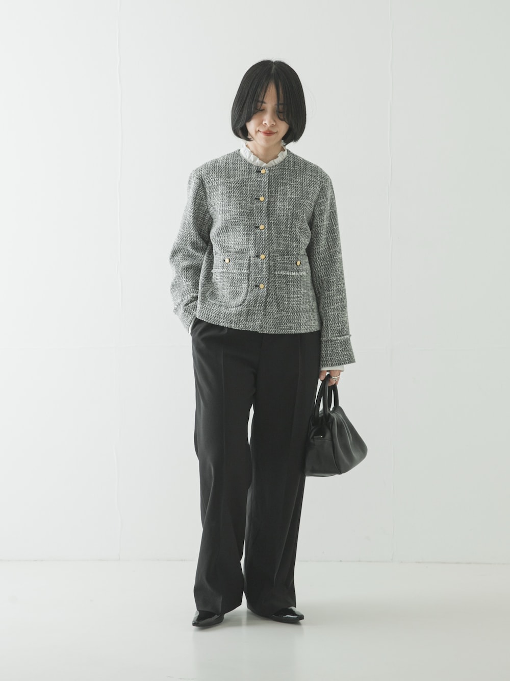 ブラック系のノーカラージャケット、ホワイト系のシャツ/ブラウス、ブラック系のその他パンツを着用したレディースの春コーディネートの1枚目の写真