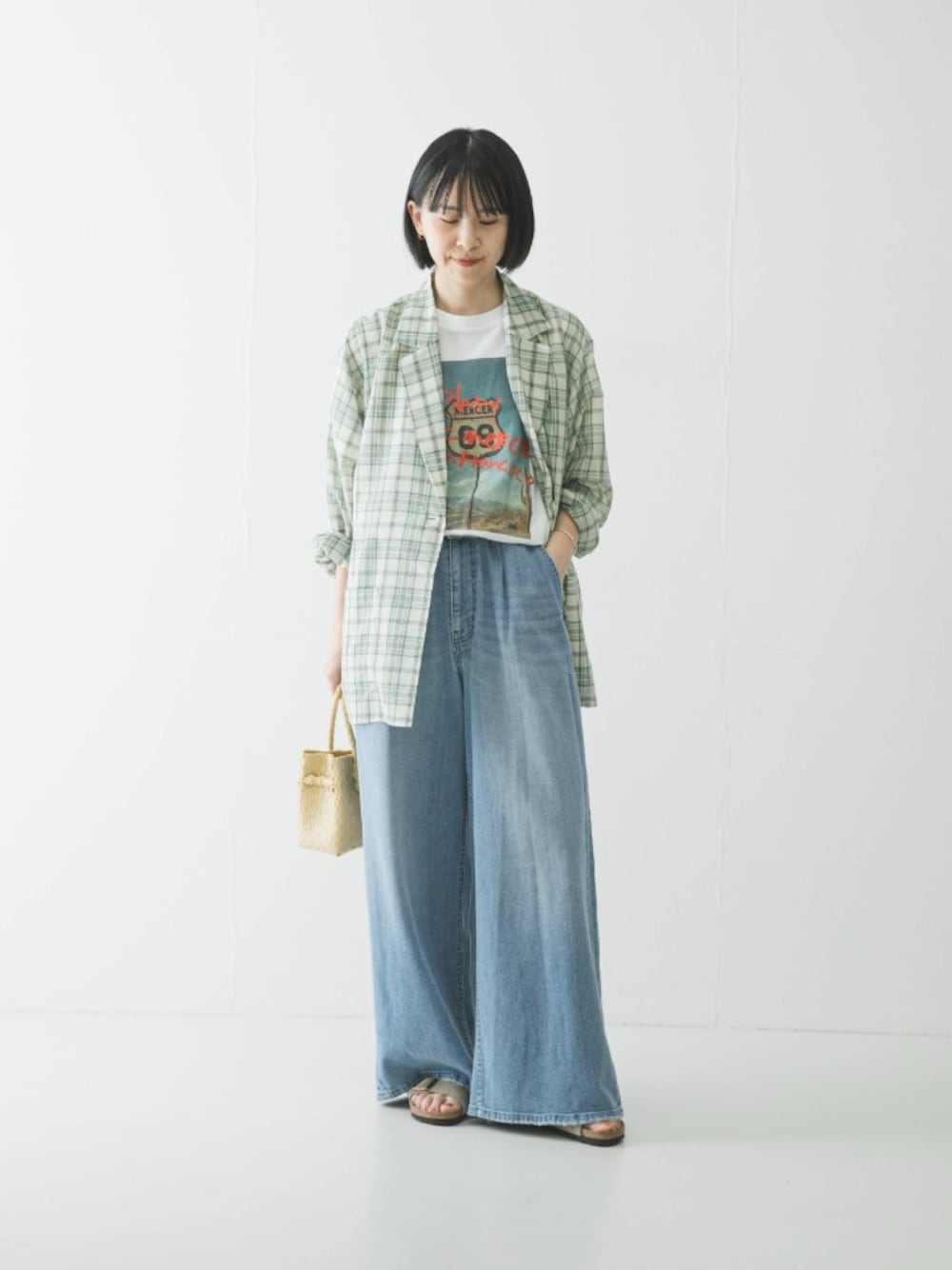 グリーン系のその他アウター、ホワイト系のTシャツ/カットソー、ベージュ系のサンダルを着用したレディースの春コーディネートの1枚目の写真