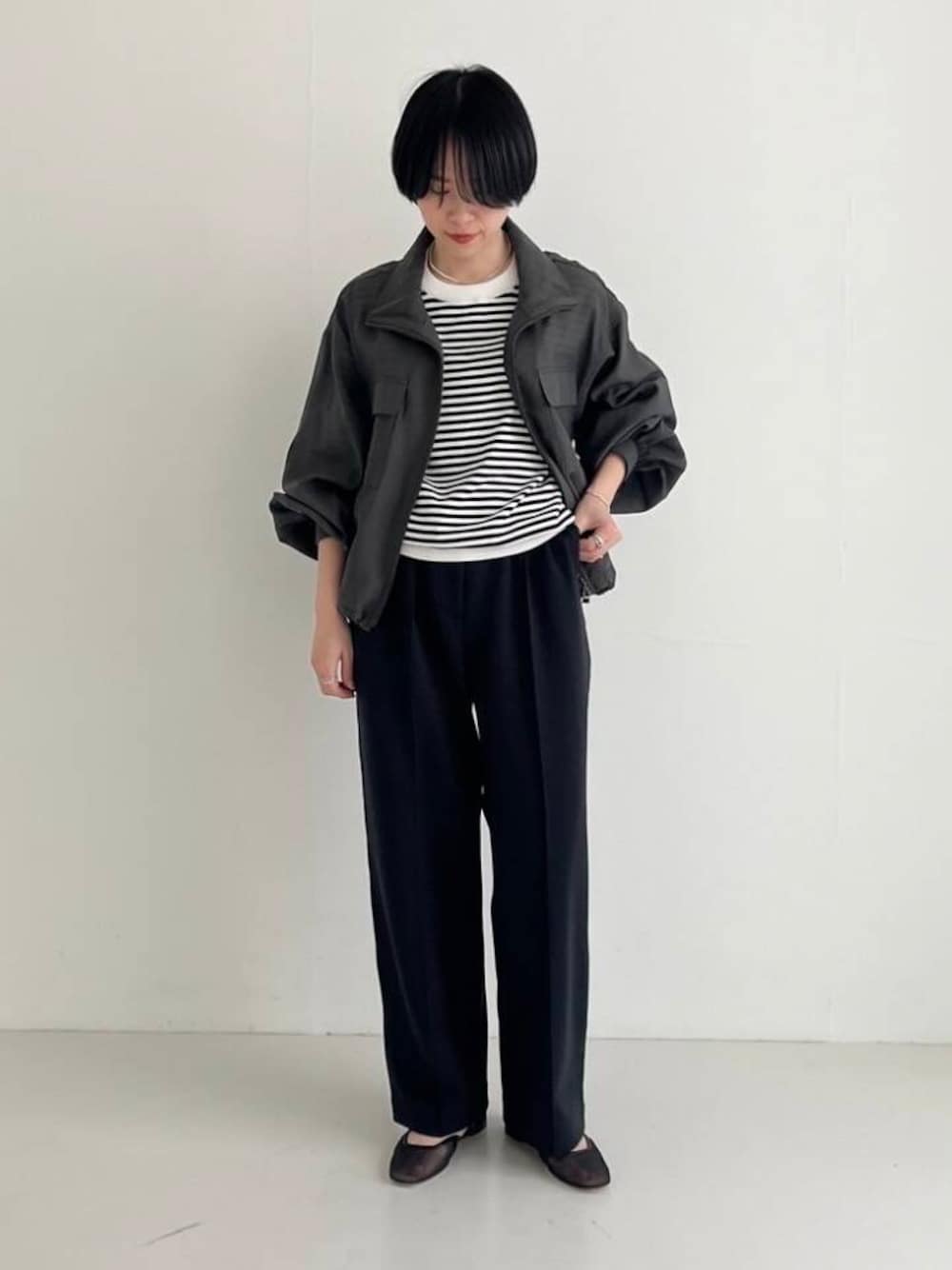 グリーン系のブルゾン、ブラック系のニット/セーター、ブラック系のその他パンツを着用したレディースの春コーディネートの1枚目の写真