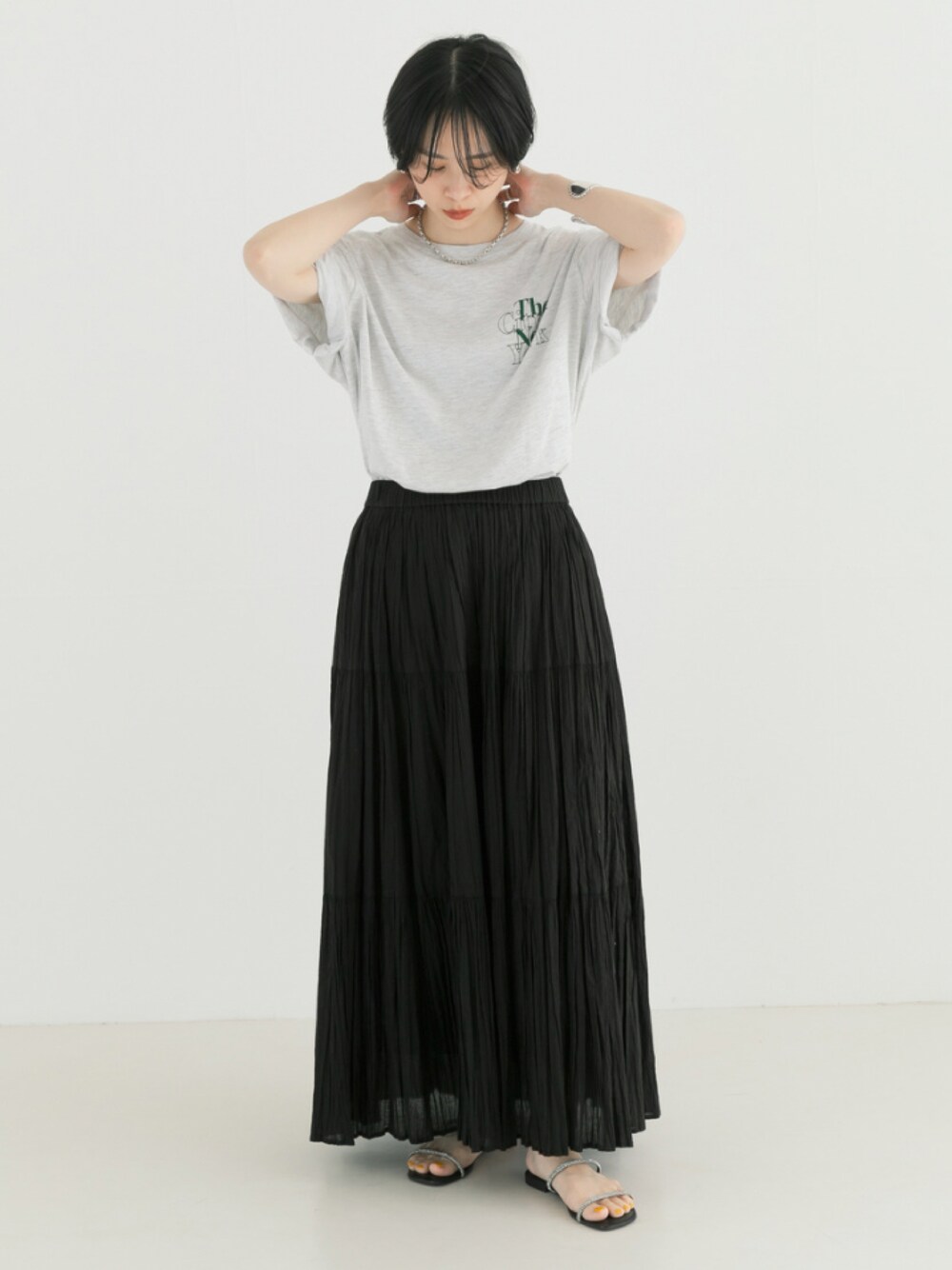 グレー系のTシャツ/カットソー、ブラック系のスカートを着用したレディースの春コーディネートの1枚目の写真