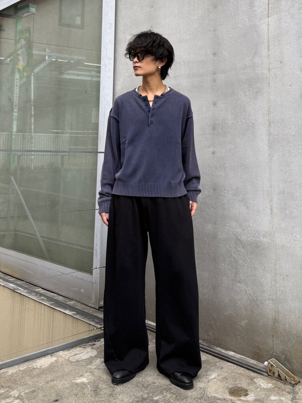 ブルー系のニット/セーター、ブラック系のスウェットパンツを着用したメンズの秋コーディネートの1枚目の写真