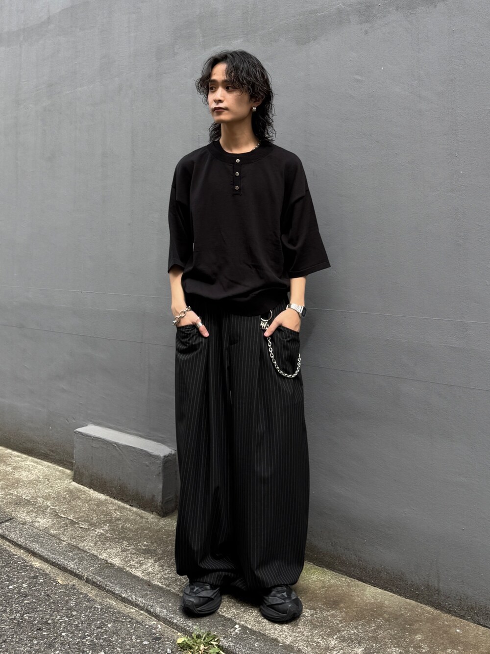 ブラック系のTシャツ/カットソー、ブラック系のスラックス、シルバー系のウォレットチェーンを着用したメンズの夏コーディネートの1枚目の写真
