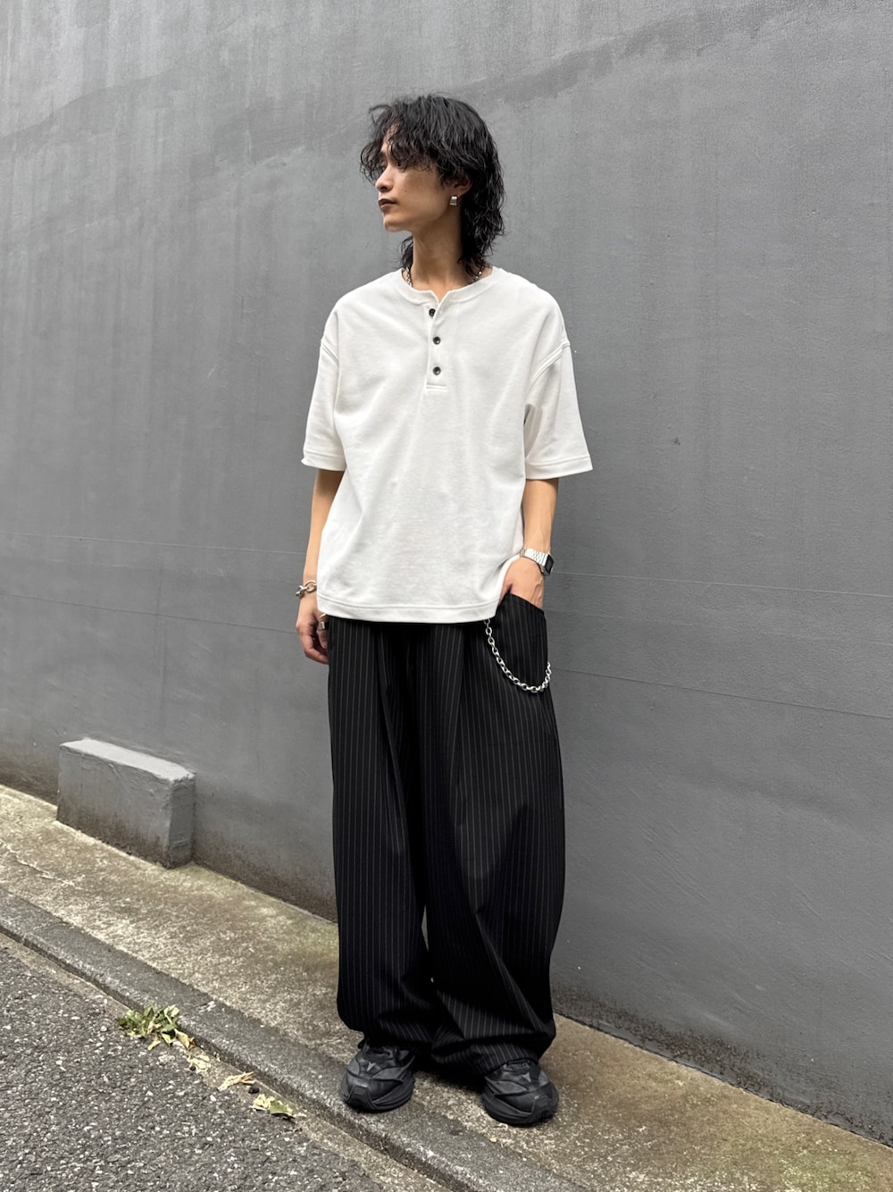 ホワイト系のTシャツ/カットソー、ブラック系のスラックス、シルバー系のウォレットチェーンを着用したメンズの夏コーディネートの1枚目の写真