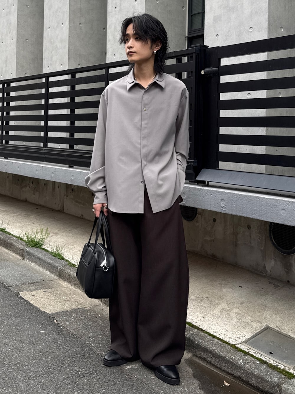 グレー系のシャツ/ブラウス、グレー系のスラックス、ブラック系のショルダーバッグを着用したメンズの春コーディネートの1枚目の写真