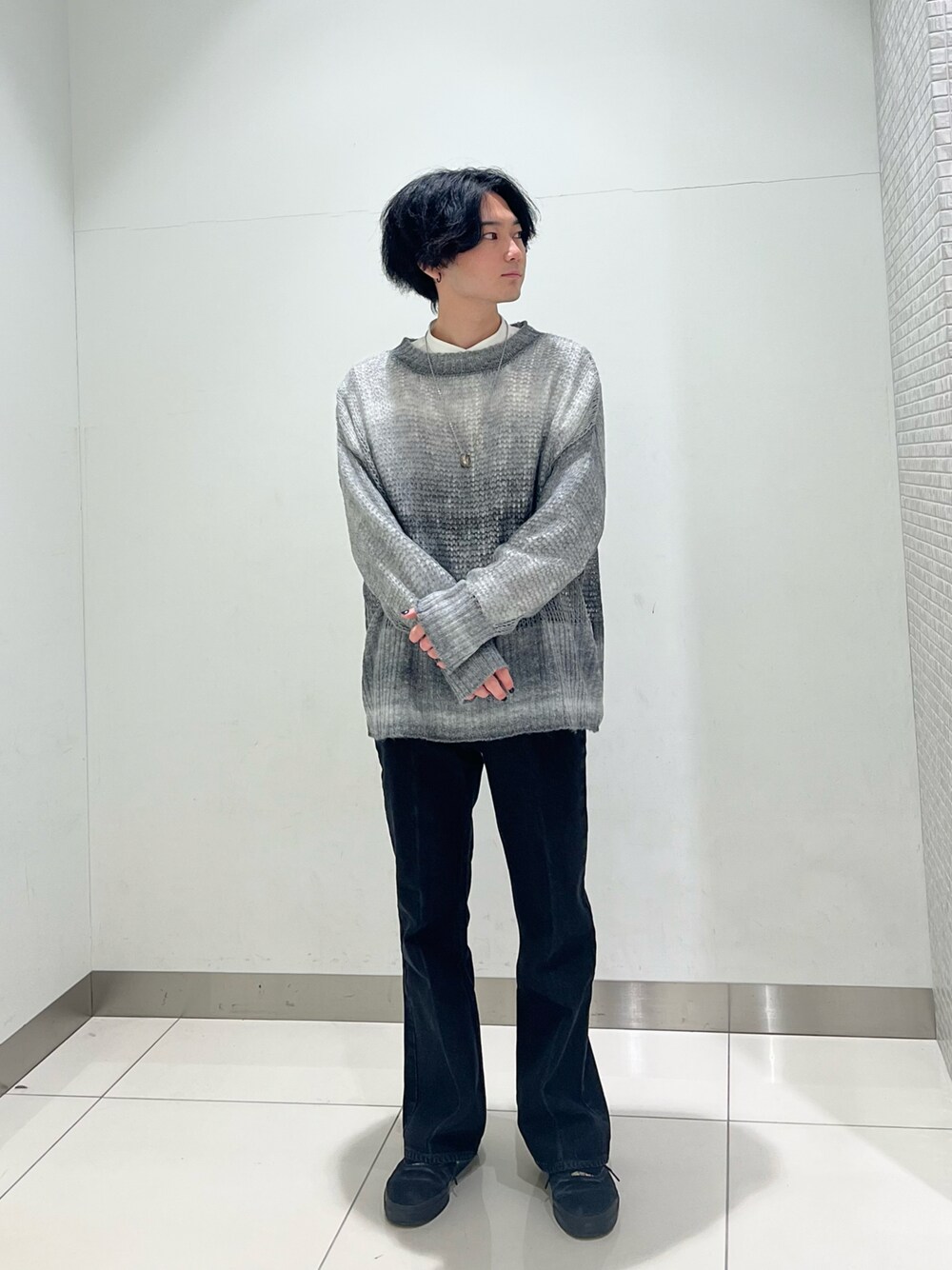 ホワイト系のシャツ/ブラウス、ブラック系のニット/セーター、ブラック系のスニーカーを着用したメンズの冬コーディネートの1枚目の写真