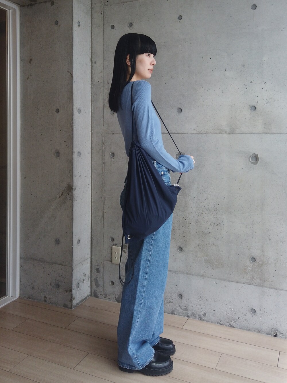 ブルー系のデニムパンツ、ブラック系のローファー、ブルー系のバックパック/リュックを着用したレディースの春コーディネートの1枚目の写真