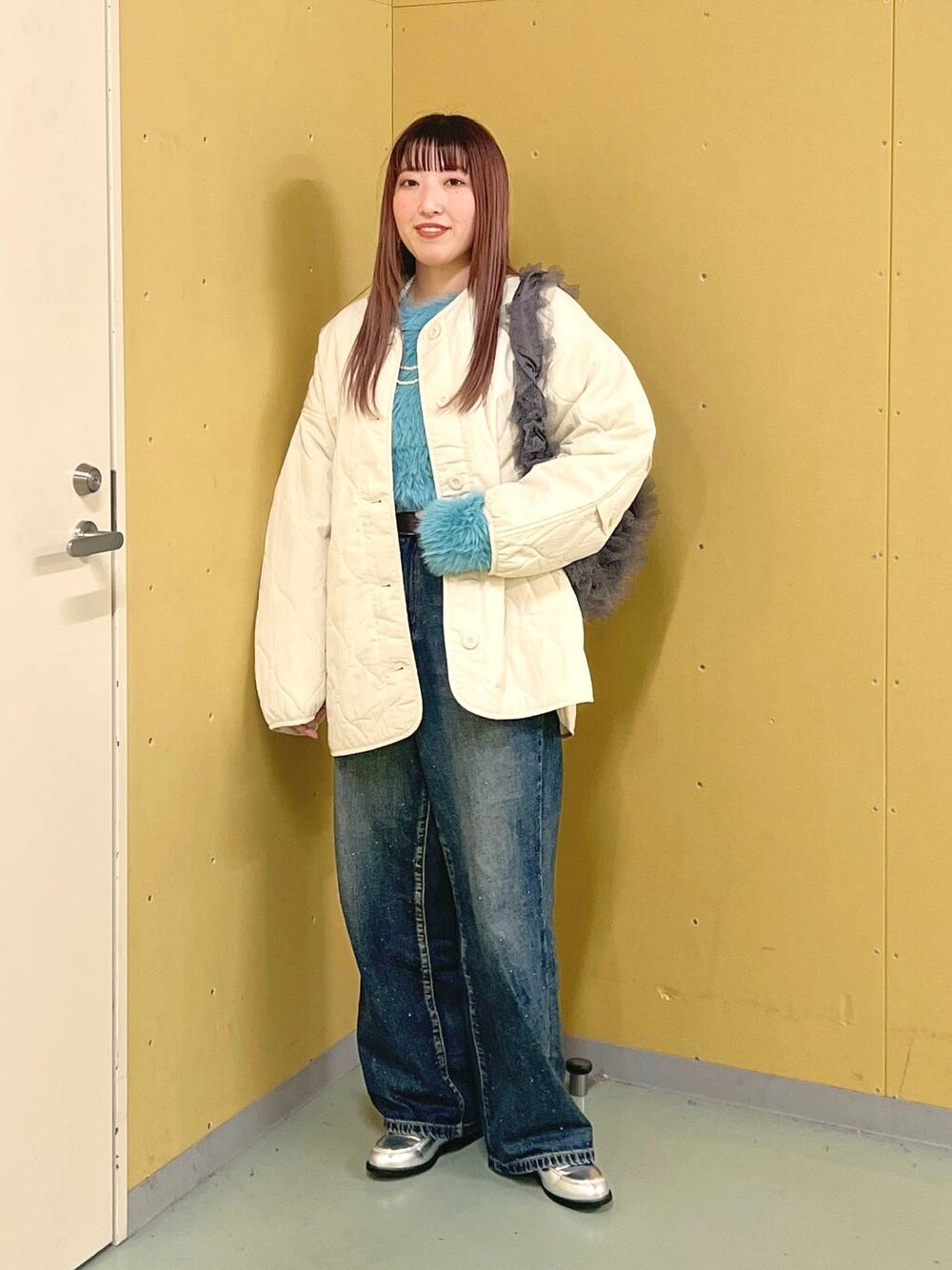 ホワイト系のブルゾン、ブルー系のデニムパンツ、シルバー系のローファーを着用したレディースの冬コーディネートの1枚目の写真