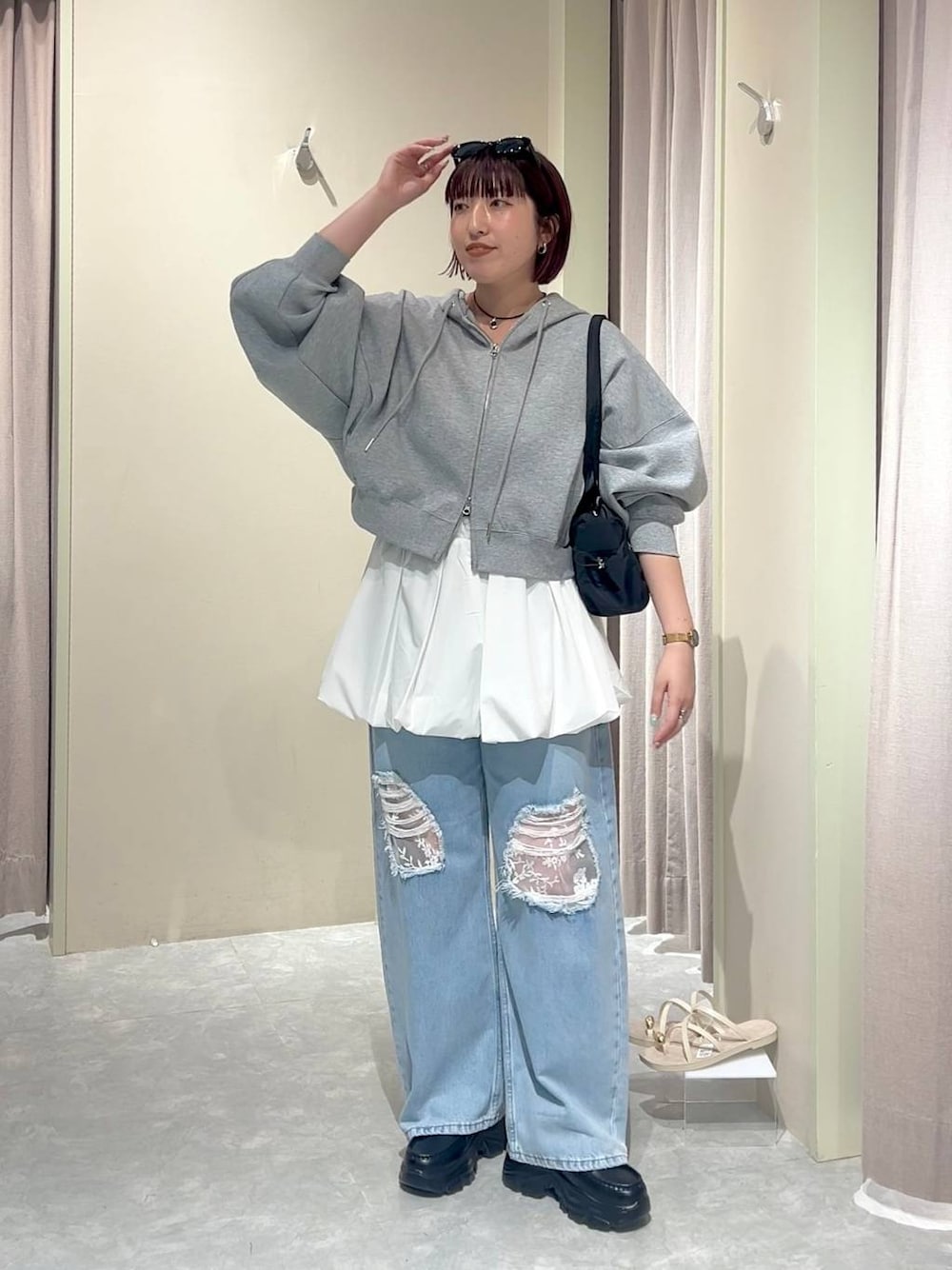 グレー系のパーカー、ブルー系のデニムパンツ、ブラック系のローファーを着用したレディースの秋コーディネートの1枚目の写真