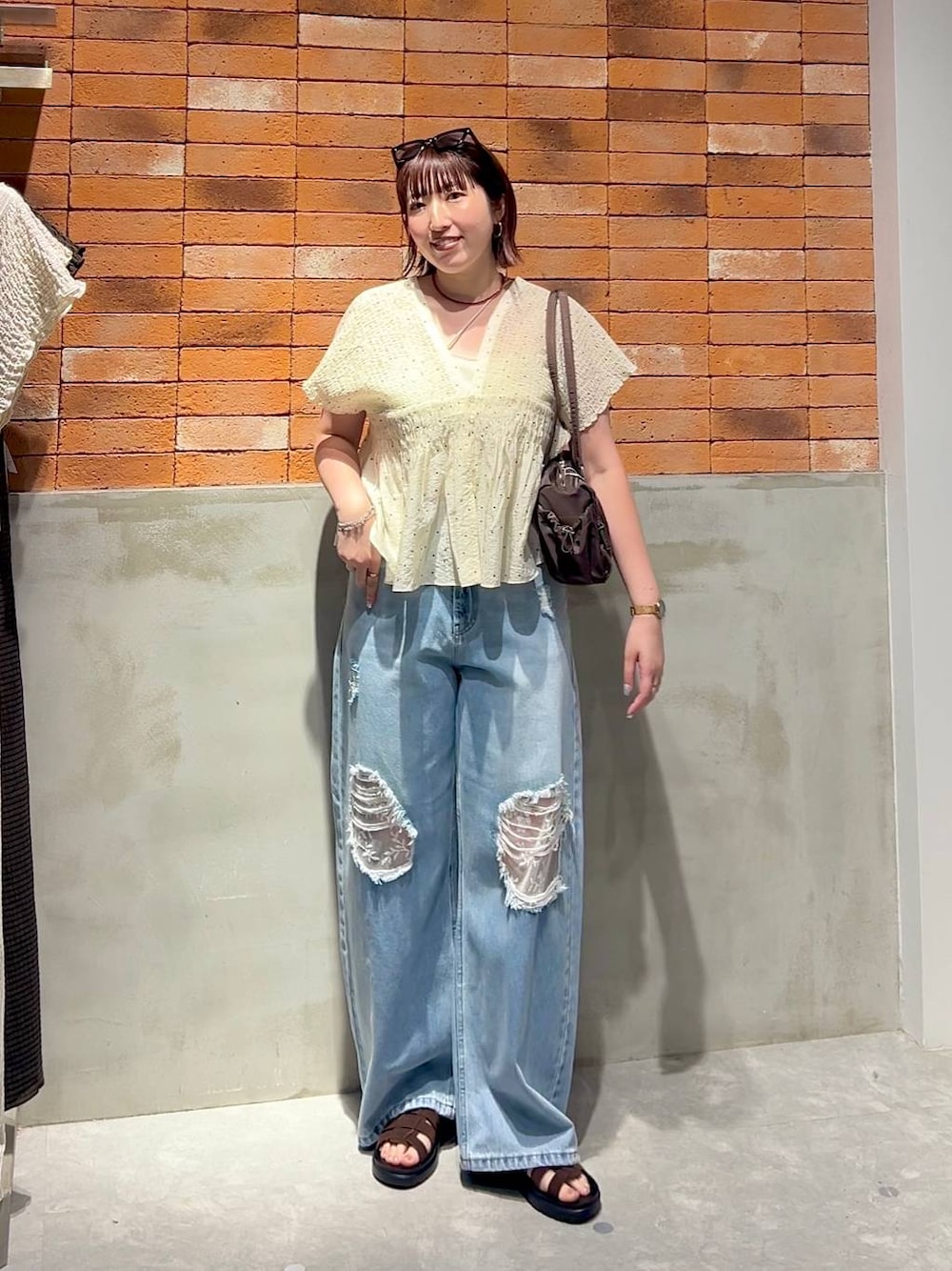 ブルー系のデニムパンツ、ブラウン系のサンダル、その他のシャツ/ブラウスを着用したレディースの夏コーディネートの1枚目の写真