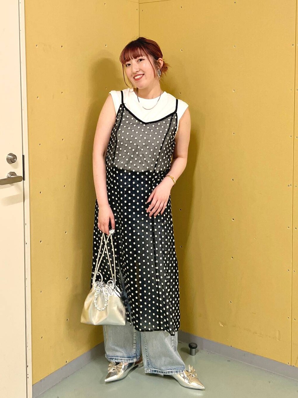 シルバー系のパンプス、シルバー系のショルダーバッグ、ブルー系のデニムパンツを着用したレディースの夏コーディネートの1枚目の写真
