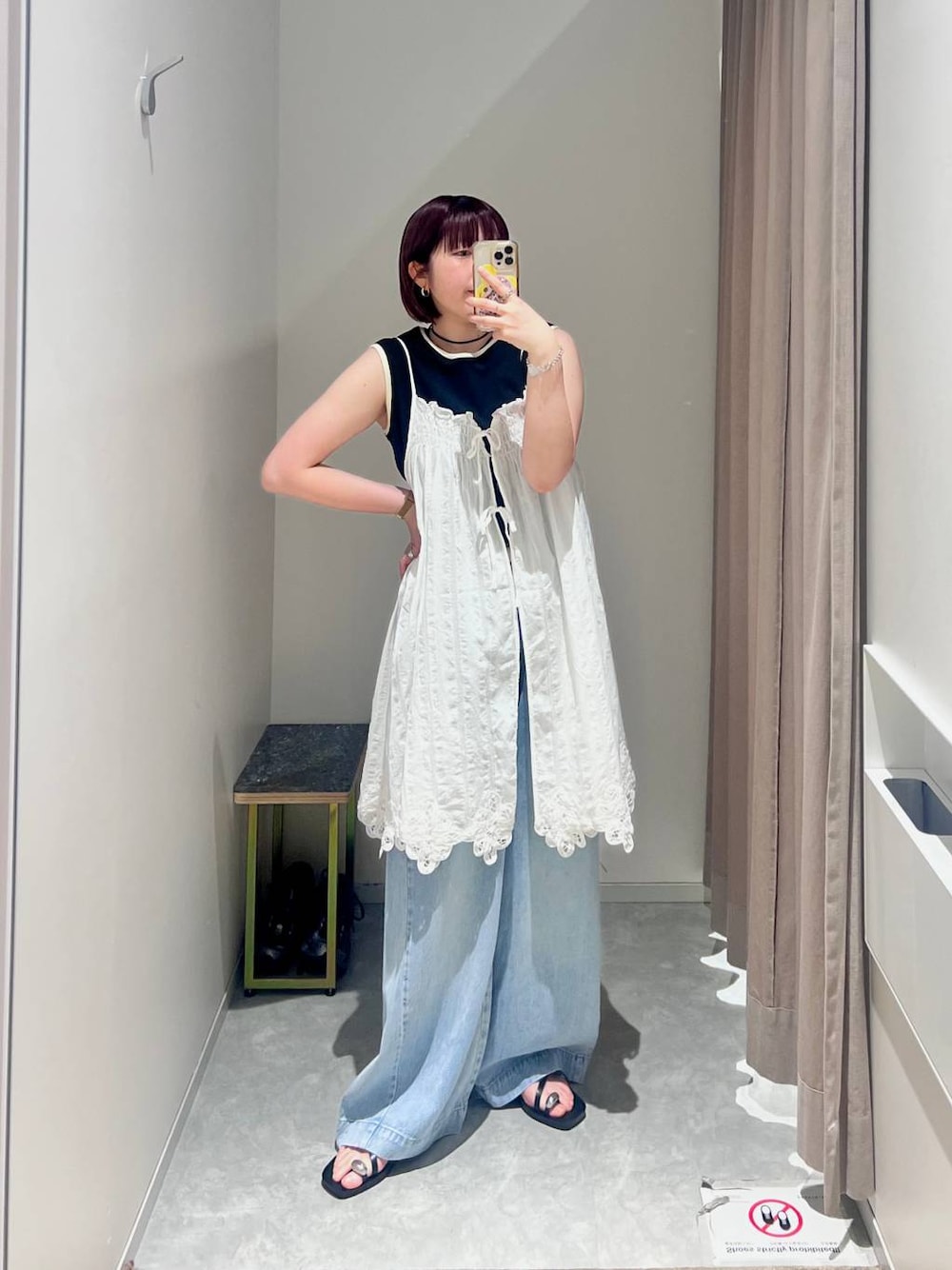 ブラック系のタンクトップ、ブルー系のデニムパンツ、ブラック系のサンダルを着用したレディースの夏コーディネートの1枚目の写真