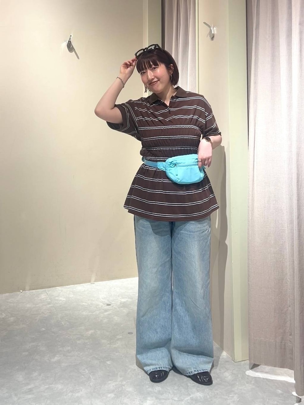 ブルー系のデニムパンツ、ブルー系のボディバッグ/ウエストポーチ、ブラウン系のローファーを着用したレディースの春コーディネートの1枚目の写真