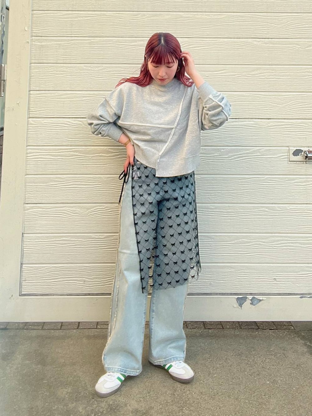ブルー系のデニムパンツ、グレー系のスウェット、シルバー系のピアス(両耳用)を着用したレディースの秋コーディネートの1枚目の写真