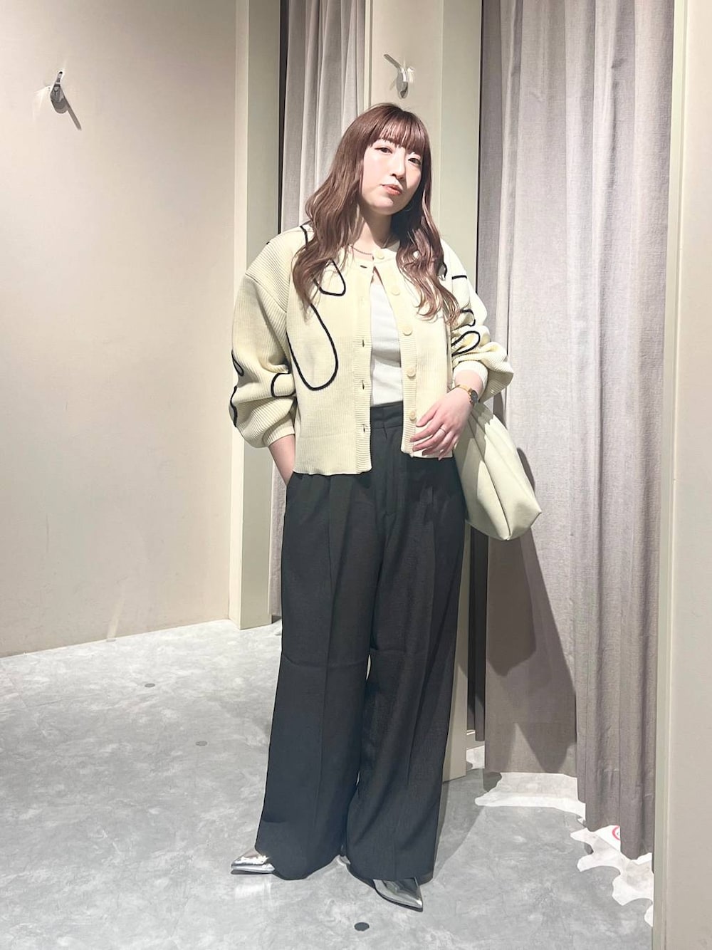 ホワイト系のショルダーバッグ、グレー系のスラックス、シルバー系のパンプスを着用したレディースの春コーディネートの1枚目の写真