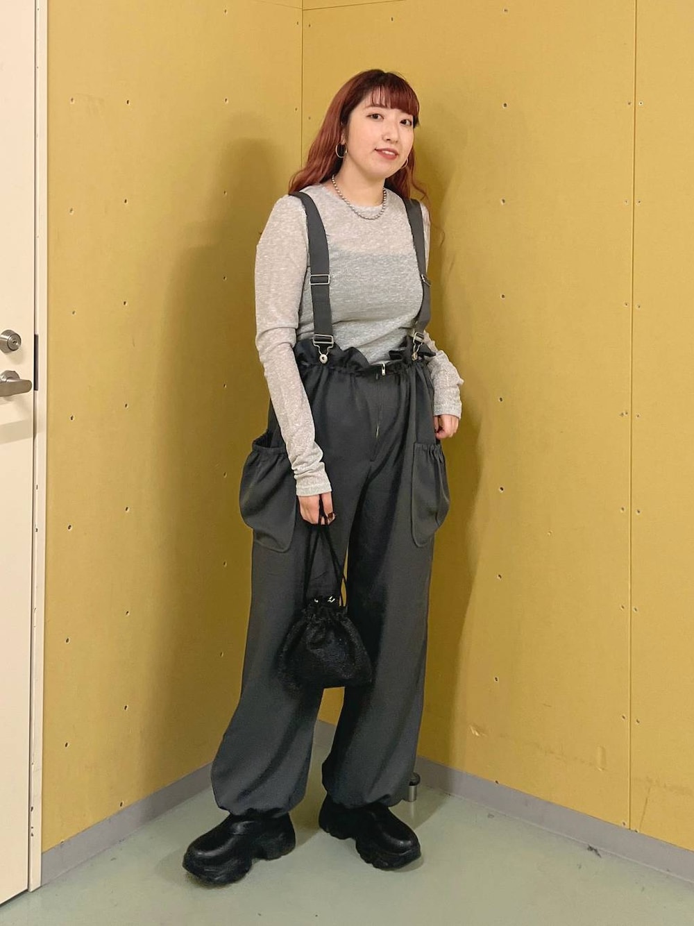 グレー系のワンピース、ブラック系のブーツ、グレー系のTシャツ/カットソーを着用したレディースの秋コーディネートの1枚目の写真