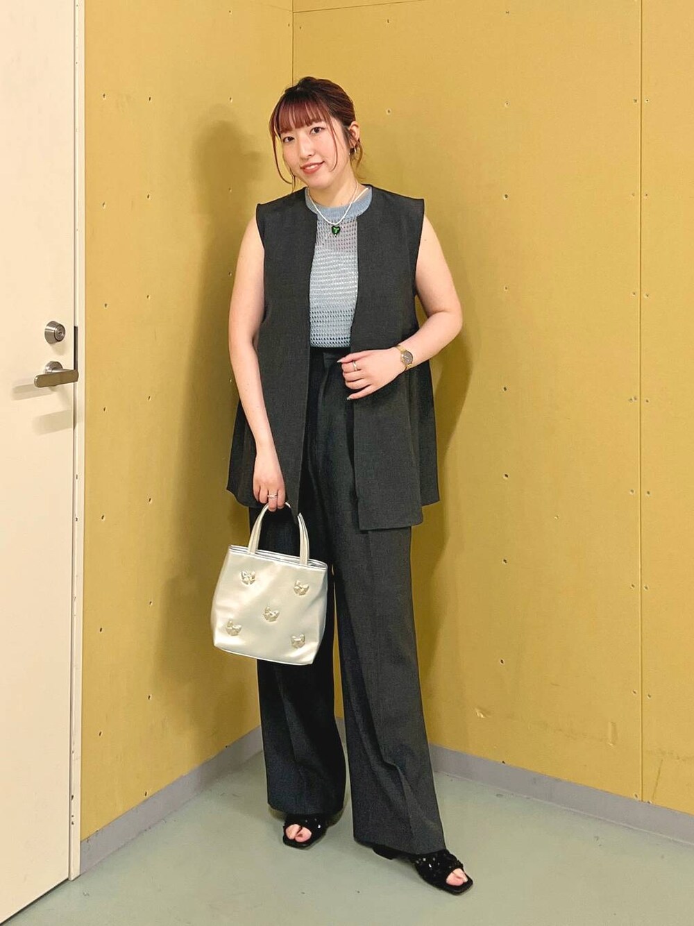 ブラック系のサンダル、シルバー系のショルダーバッグ、グレー系のベストを着用したレディースの夏コーディネートの1枚目の写真