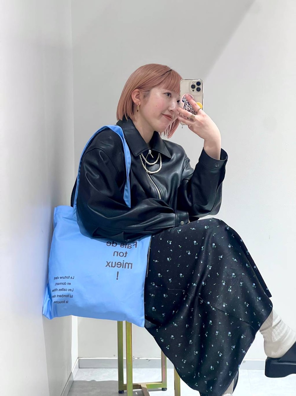 ブラック系のスカート、ブラック系のサンダル、ブルー系のトートバッグを着用したレディースの冬コーディネートの1枚目の写真