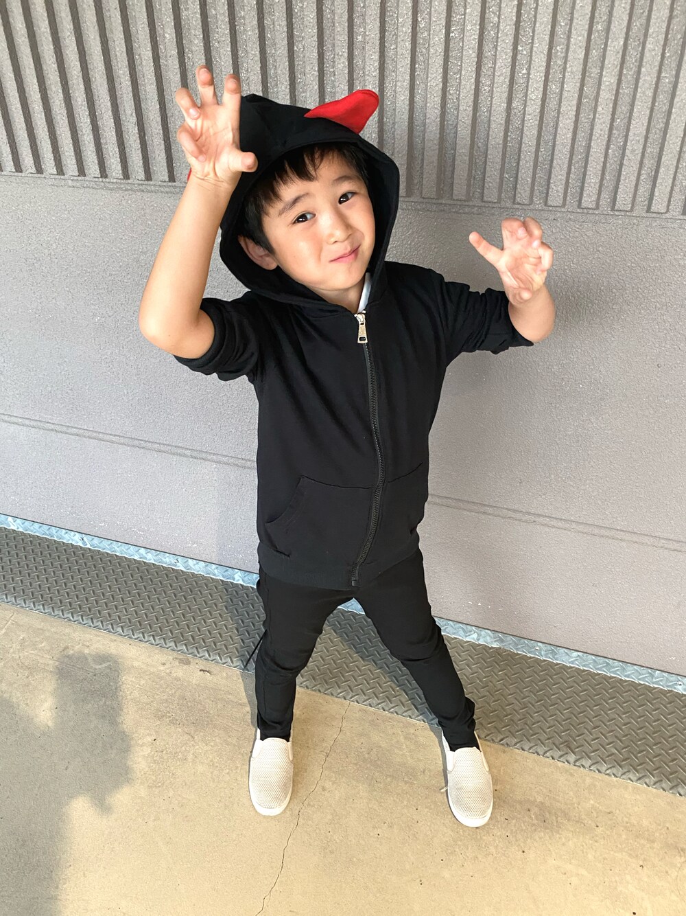 ブラック系のチノパンツ、ブラック系のパーカー、ベージュ系のスリッポンを着用したキッズの秋コーディネートの1枚目の写真