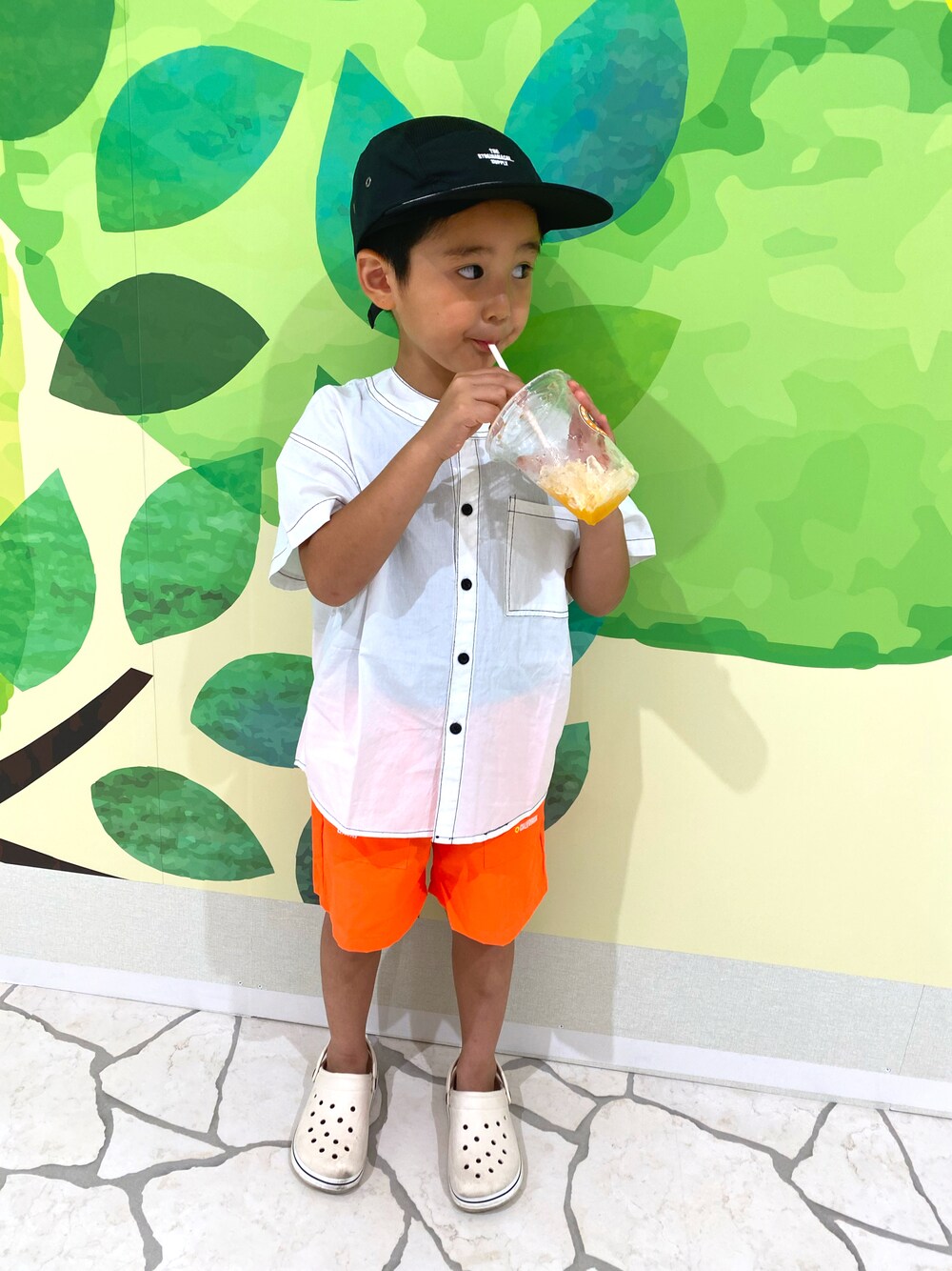 ホワイト系のシャツ/ブラウス、オレンジ系のパンツ、ブラック系の帽子を着用したキッズの夏コーディネートの1枚目の写真