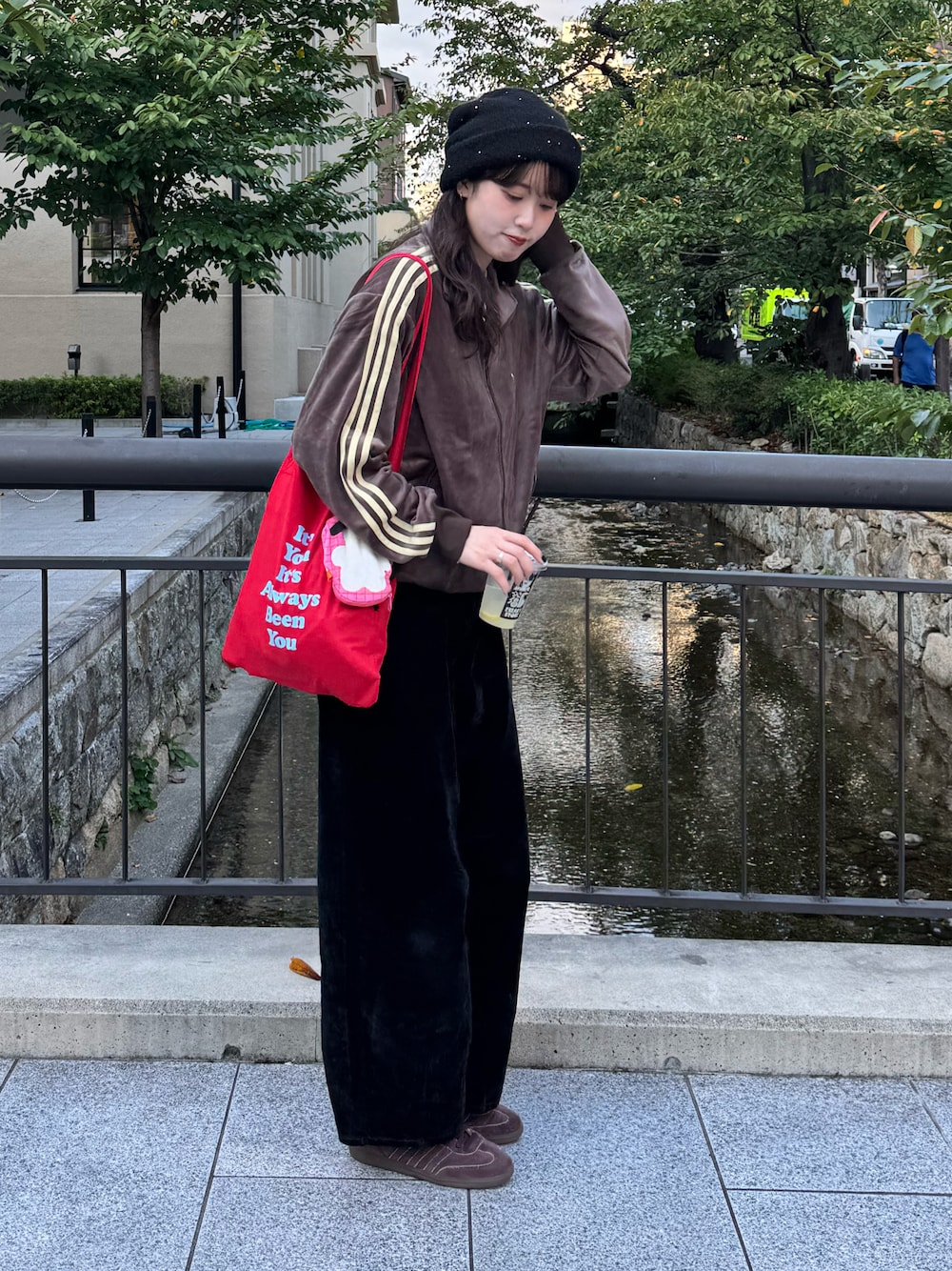 ブラウン系のその他アウター、レッド系のトートバッグ、ブラック系のデニムパンツを着用したレディースの秋コーディネートの1枚目の写真