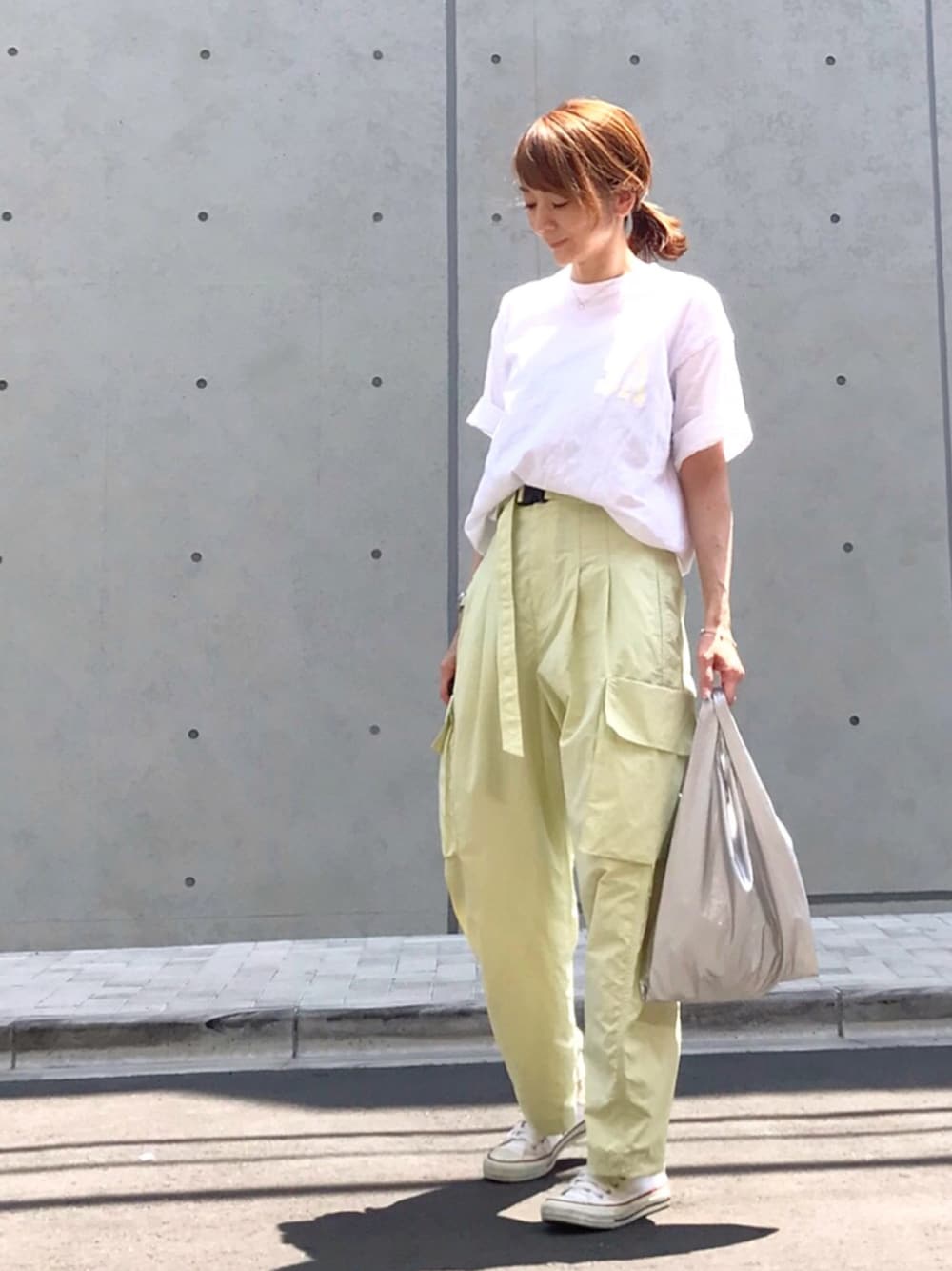 グリーン系のその他パンツ、ホワイト系のTシャツ/カットソー、シルバー系のエコバッグ/サブバッグを着用したレディースの春コーディネートの1枚目の写真