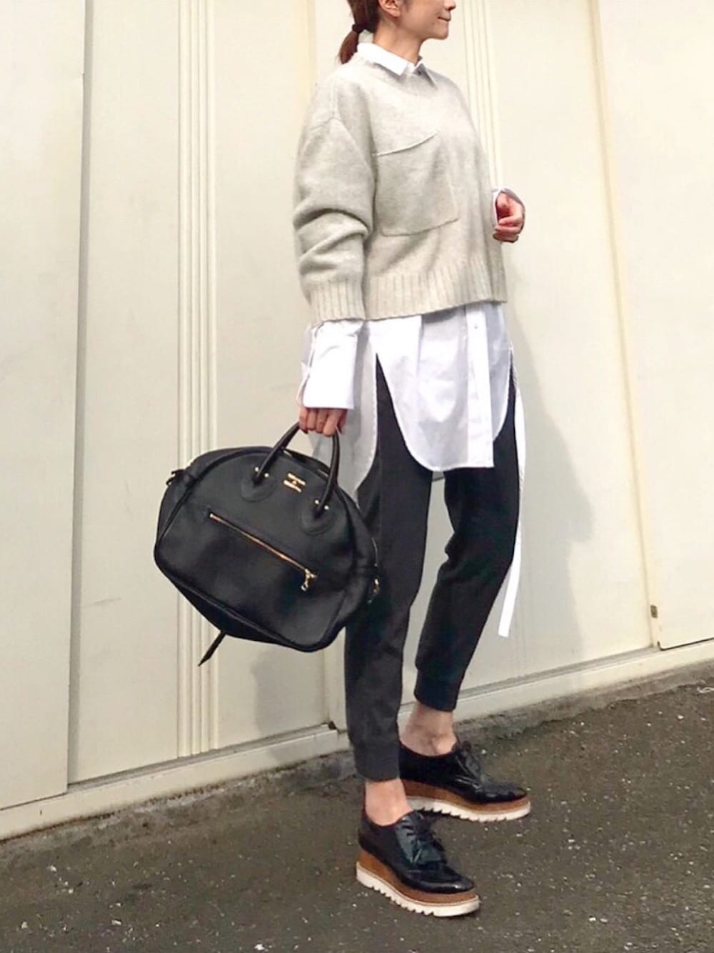 ホワイト系のシャツ/ブラウス、グレー系のニット/セーター、ブラック系のドレスシューズを着用したレディースの春コーディネートの1枚目の写真
