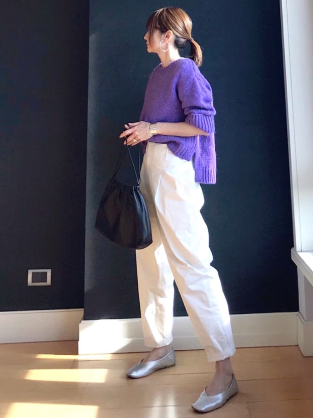 パープル系のニット/セーター、ブラウン系のハンドバッグ、ホワイト系のその他パンツを着用したレディースの冬コーディネートの1枚目の写真