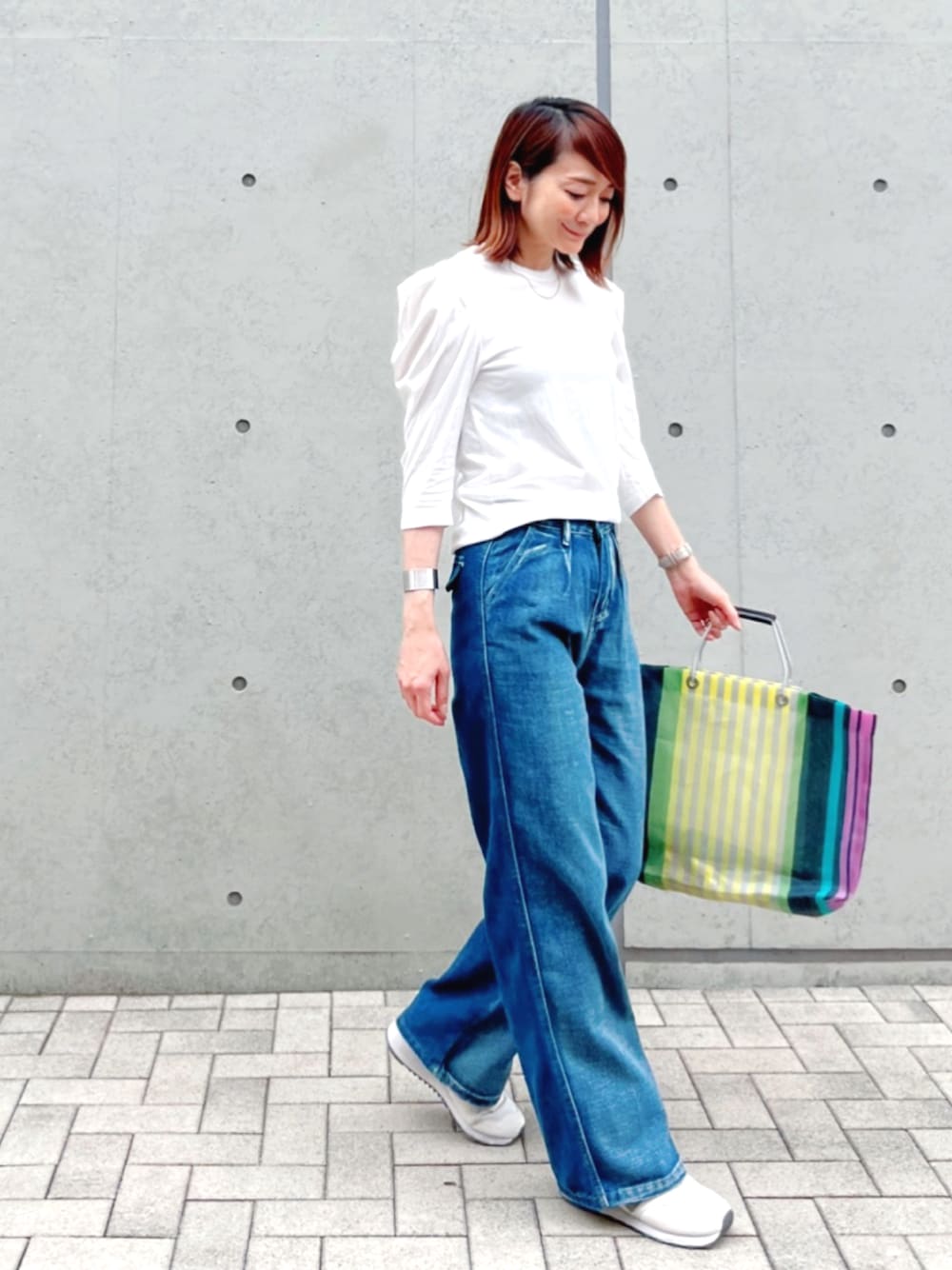 ブルー系のデニムパンツ、ホワイト系のTシャツ/カットソー、その他のバッグを着用したレディースの春コーディネートの1枚目の写真