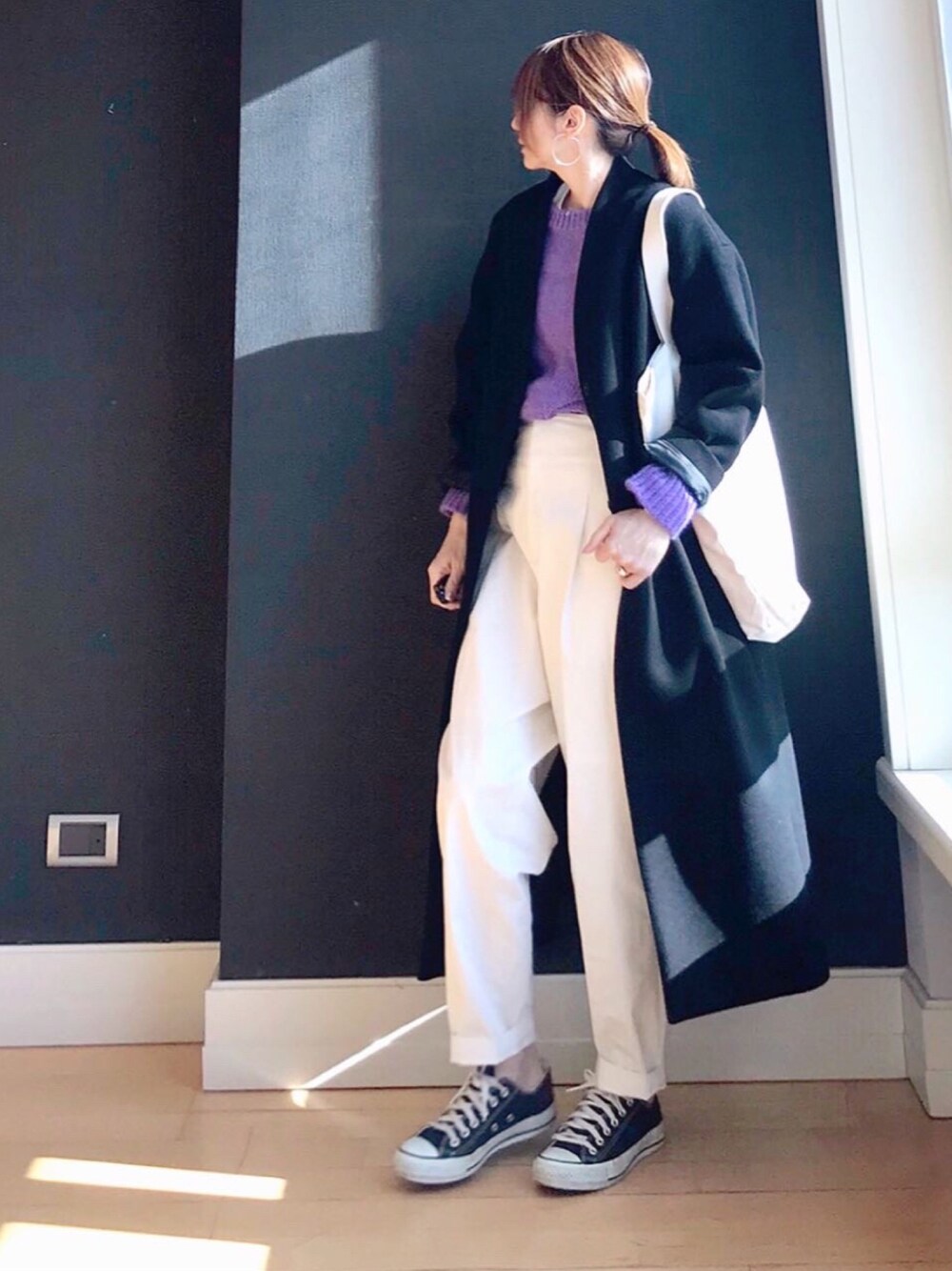 ブラック系のノーカラーコート、パープル系のニット/セーター、ホワイト系のその他パンツを着用したレディースの冬コーディネートの1枚目の写真