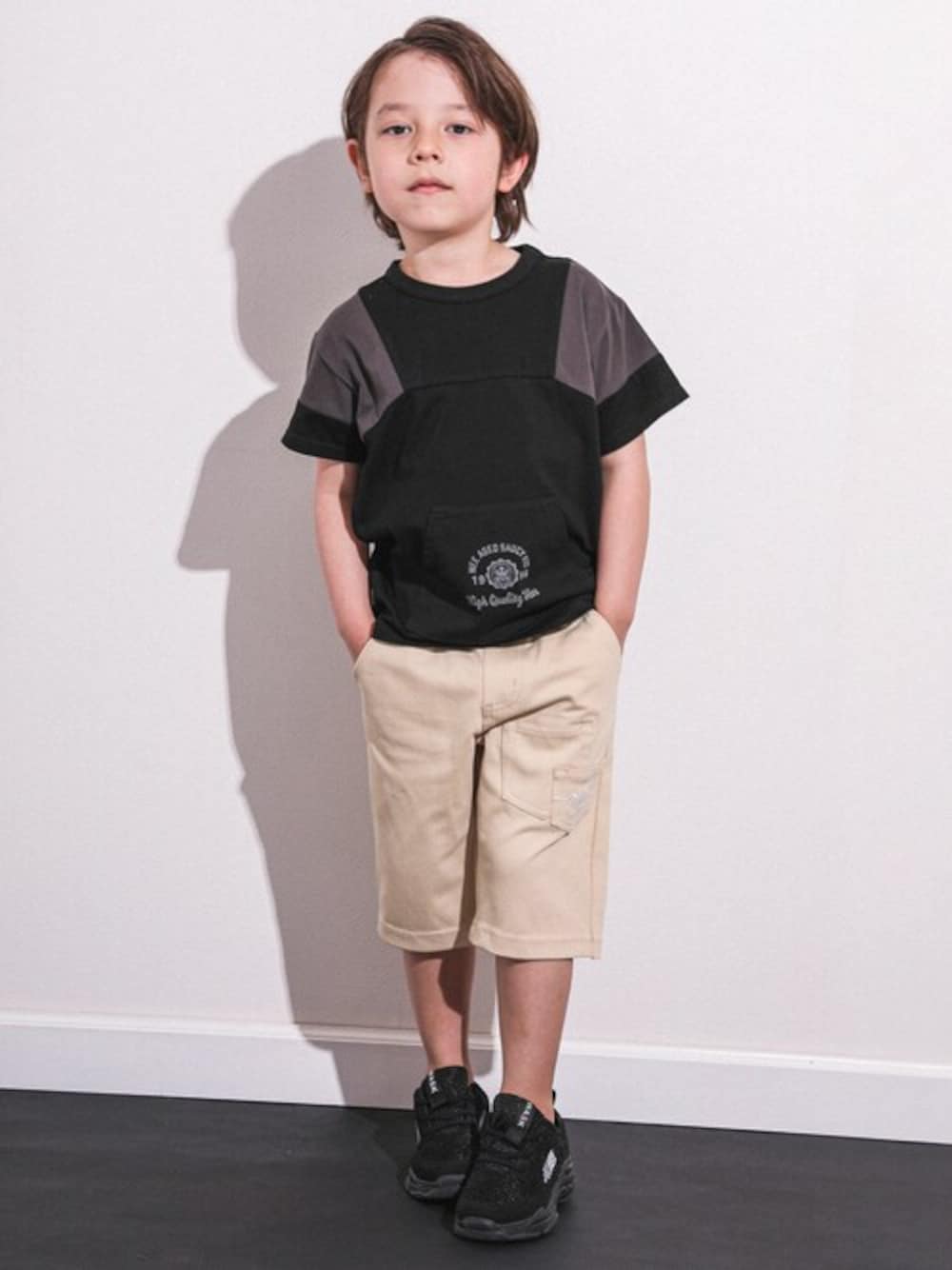 ブラック系のTシャツ/カットソー、ベージュ系のカーゴパンツを着用したキッズの春コーディネートの1枚目の写真
