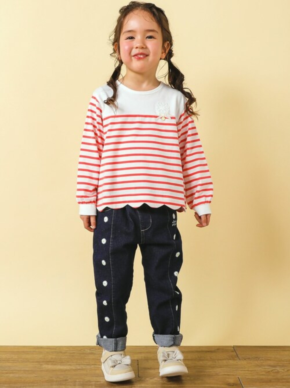 「デニムパンツ、公園、春コーデ、スカラップ、ピクニック、カジュアルコーデ、ボーダーTシャツ、マーガレット、SLAPSLIP、スラップスリップ」｜「SLAP SLIPのスカラップ 裾 ボーダー 柄 天竺 長袖 Tシャツ (80~130cm)（Tシャツ/カットソー、ピンク系）」を使った、BEBE ONLINE STOREさん（キッズ・110cm）の春コーディネートの1枚目の写真