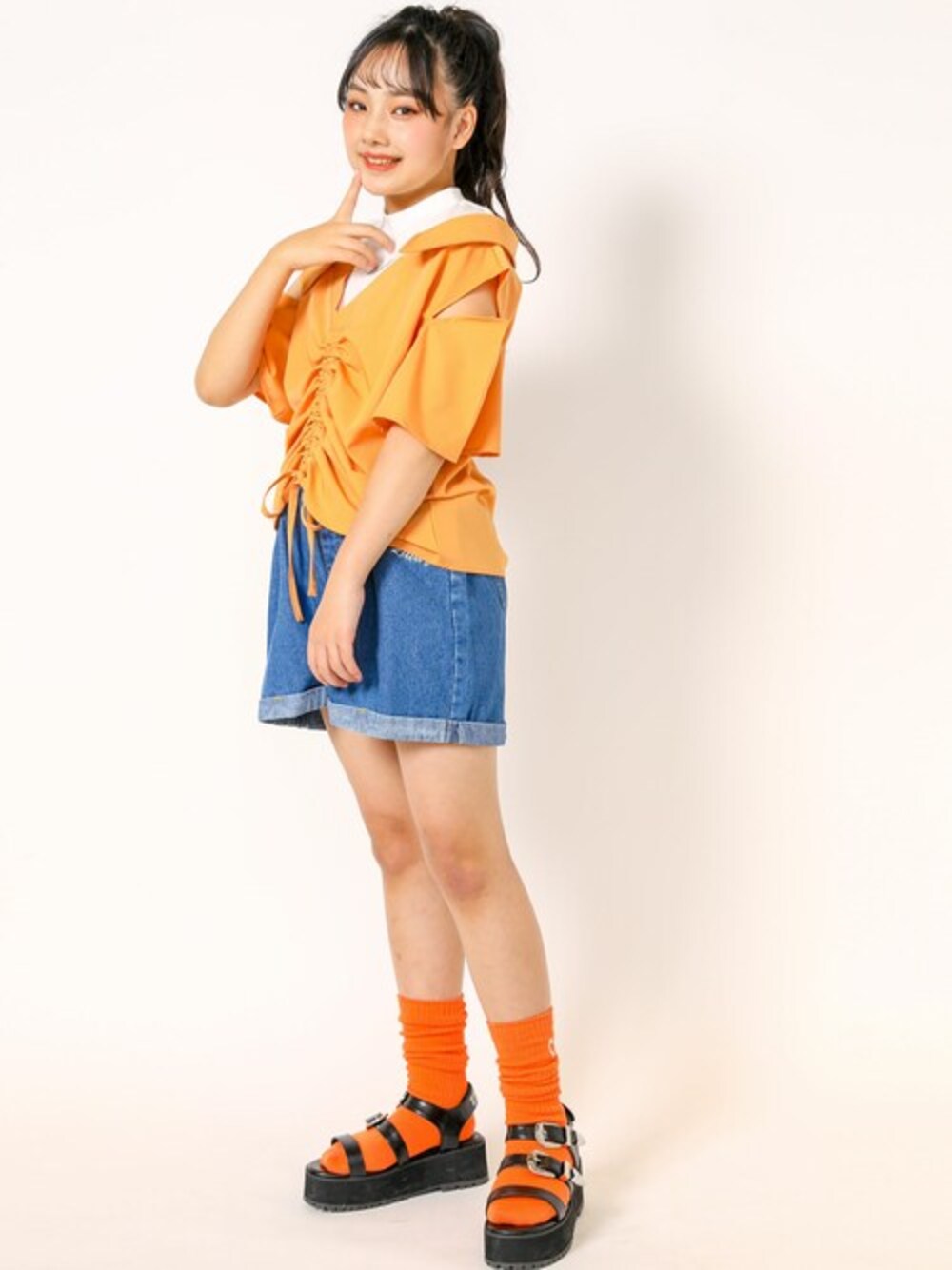 オレンジ系のTシャツ/カットソー、その他のデニムパンツ、ブラック系のサンダルを着用したキッズの春コーディネートの1枚目の写真