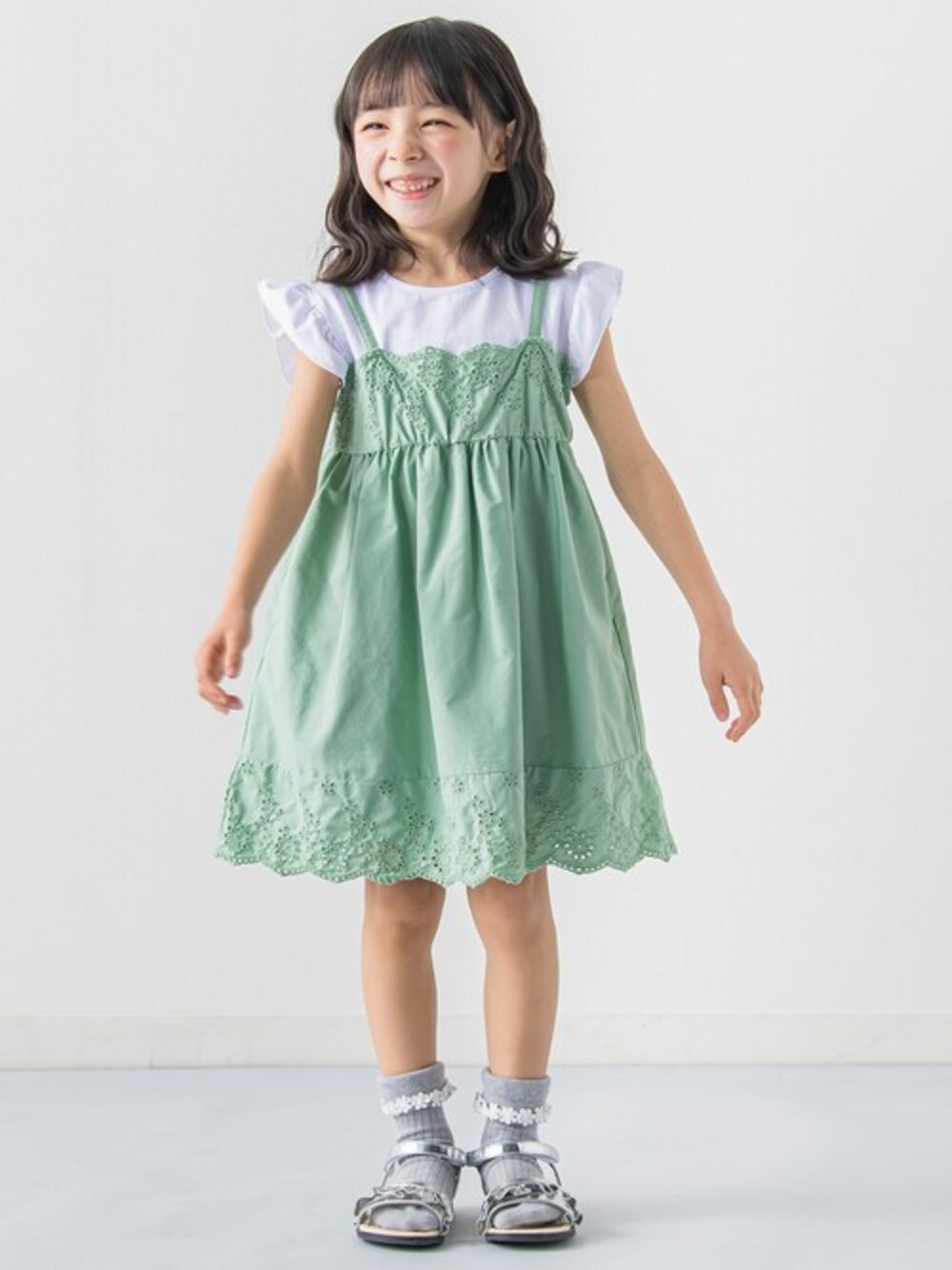グリーン系のワンピースを着用したキッズの春コーディネートの1枚目の写真