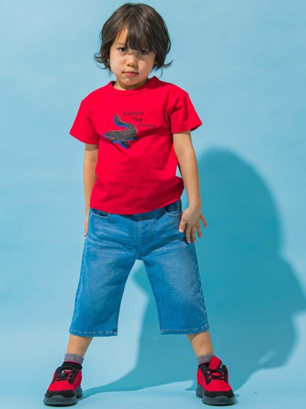 レッド系のTシャツ/カットソー、ブルー系のデニムパンツを着用したキッズの春コーディネートの1枚目の写真