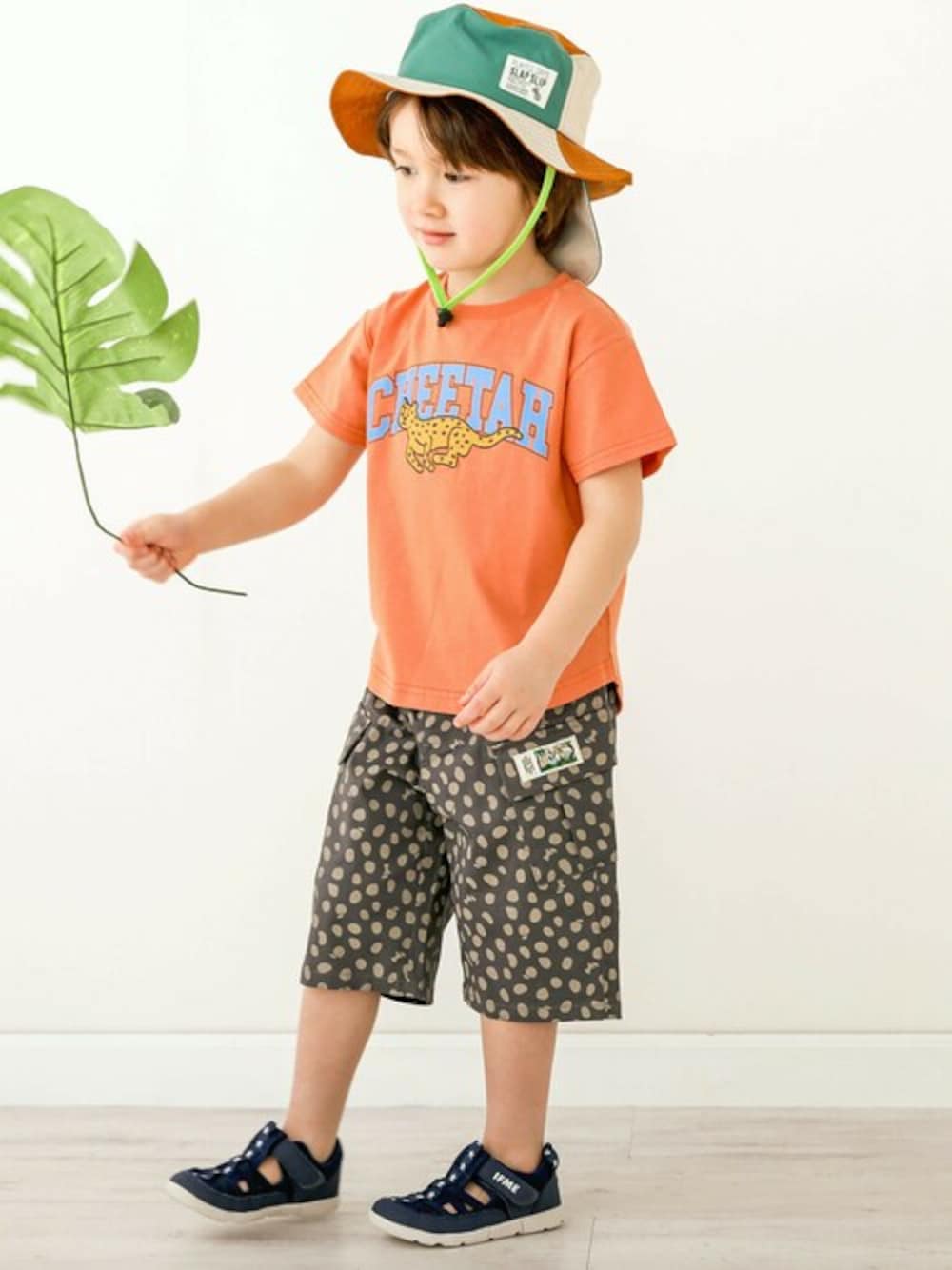 オレンジ系のTシャツ/カットソー、ブラウン系のカーゴパンツ、オレンジ系のハットを着用したキッズの春コーディネートの1枚目の写真