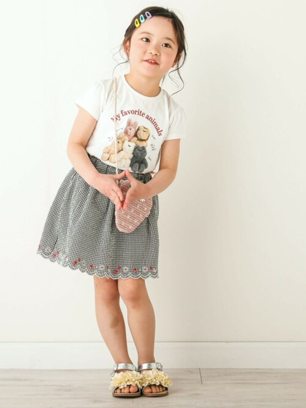 ホワイト系のTシャツ/カットソー、ブラック系のスカート、グレー系のサンダルを着用したキッズの春コーディネートの1枚目の写真