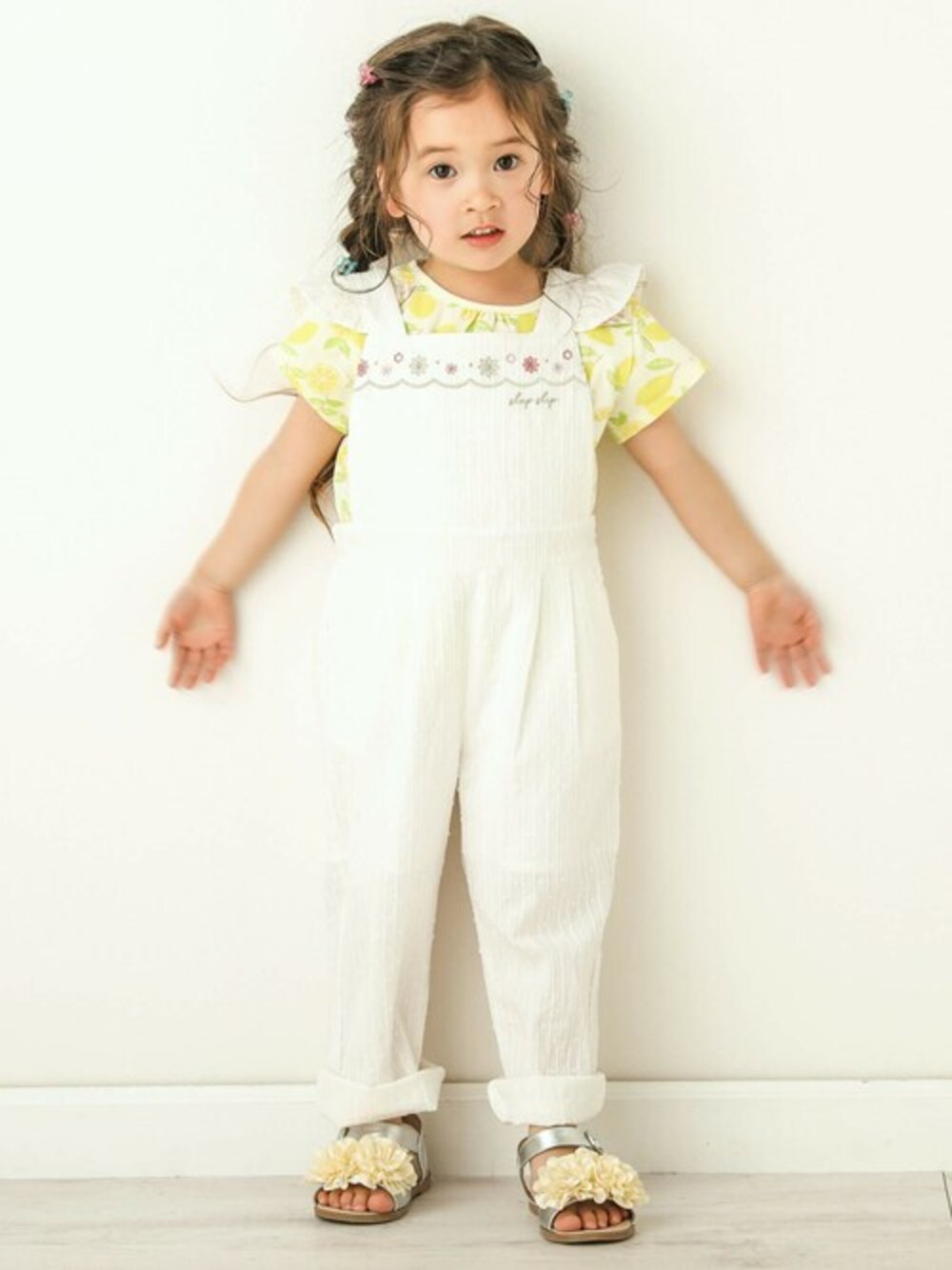 イエロー系のTシャツ/カットソー、ホワイト系のサロペット/オーバーオール、グレー系のサンダルを着用したキッズの春コーディネートの1枚目の写真