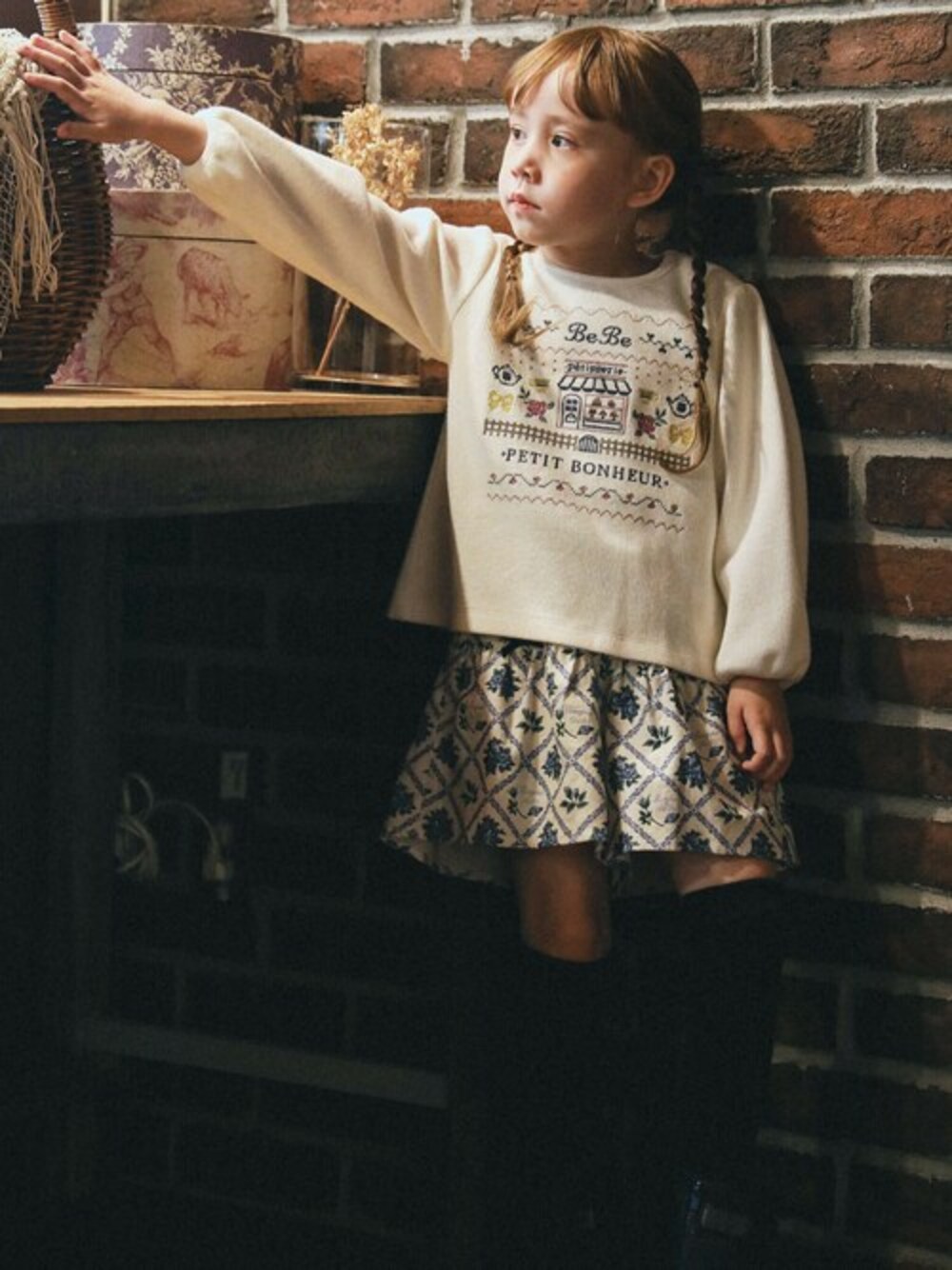 ホワイト系のスウェット、ブルー系のスカートを着用したキッズの秋コーディネートの1枚目の写真