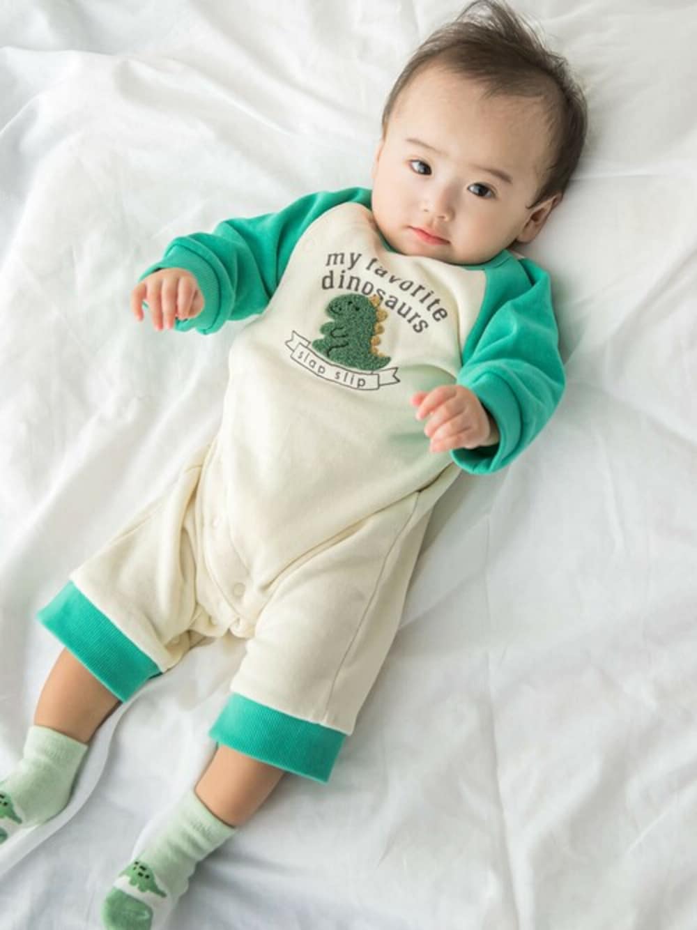 グリーン系のロンパース、グリーン系のベビーシューズ/ベビーソックスを着用したキッズの秋コーディネートの1枚目の写真