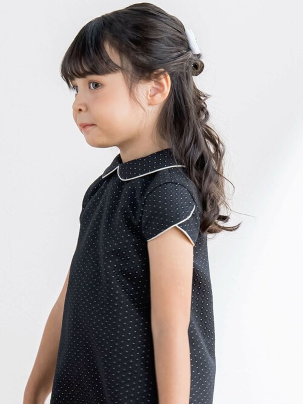 ブラック系のワンピース、ホワイト系のバレッタ/ヘアクリップを着用したキッズの冬コーディネートの1枚目の写真