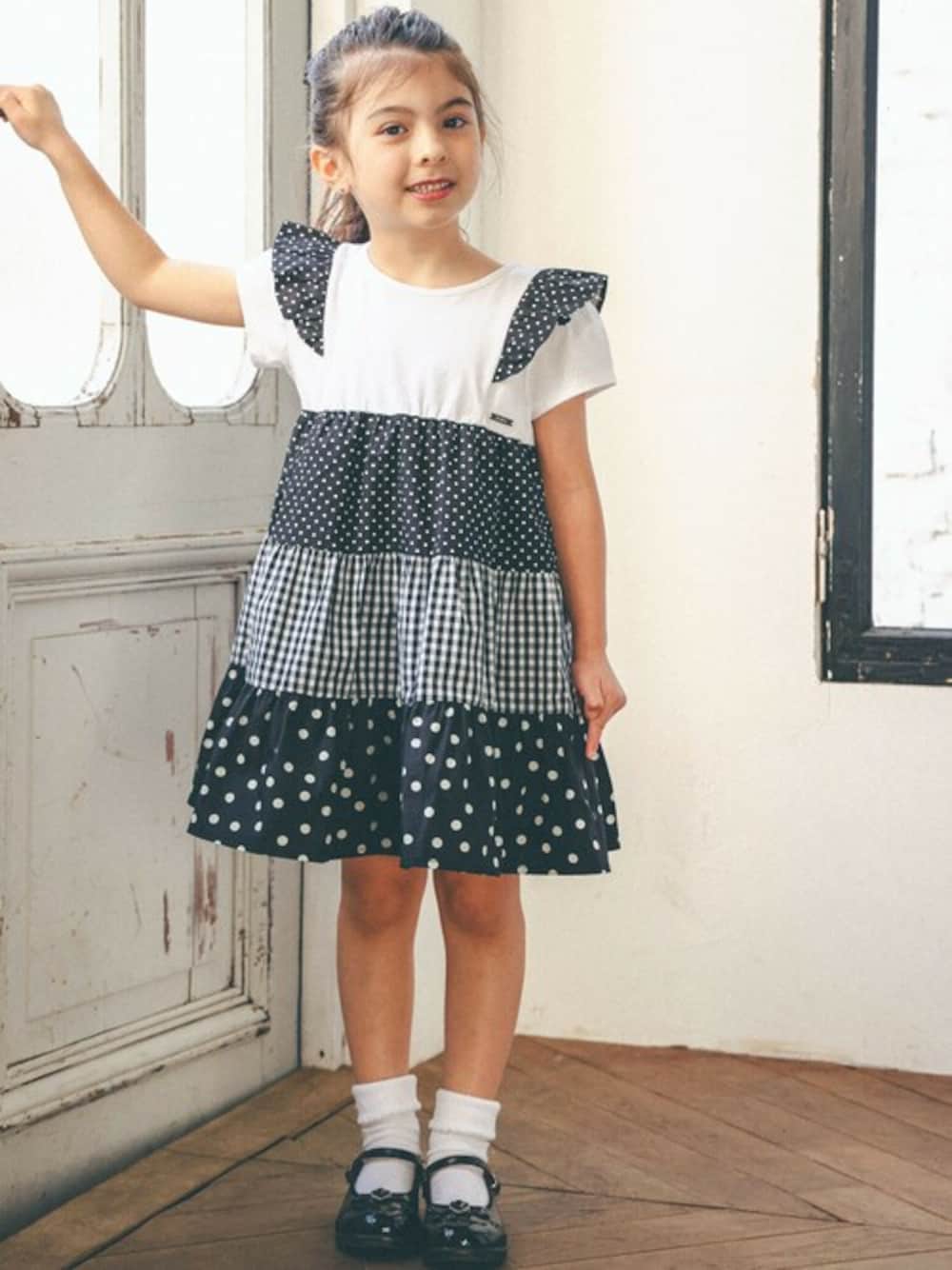 ブラック系のワンピース、ブラック系のドレスシューズを着用したキッズの春コーディネートの1枚目の写真